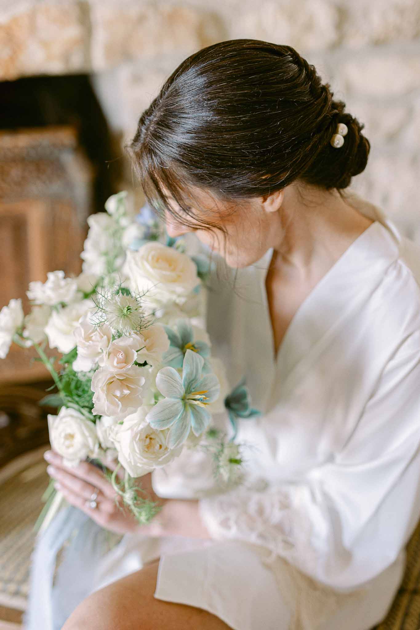 Bride holding wedding bouquet in indoor portrait composition