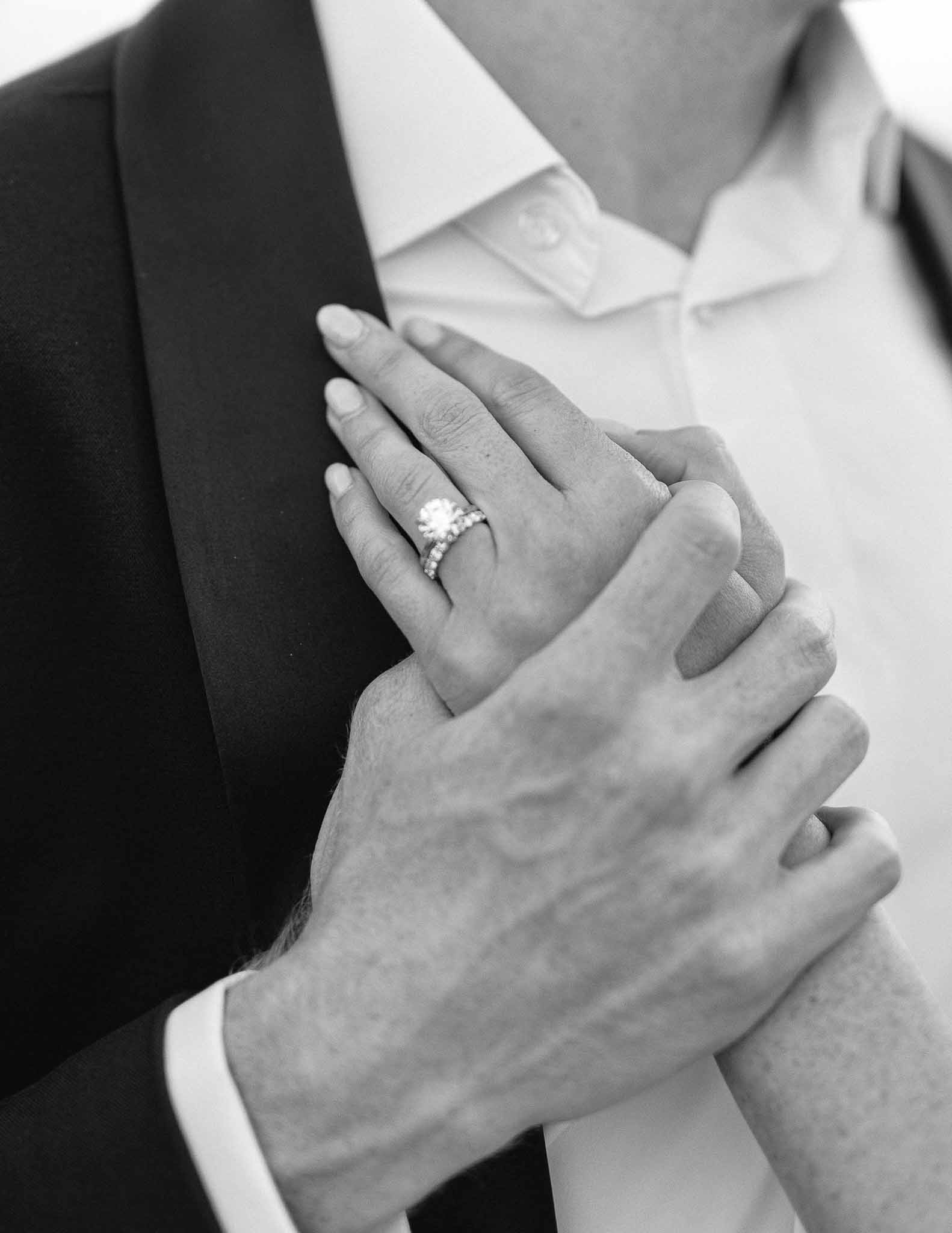 Close-up of couple's hands showing wedding rings and engagement ring during wedding ceremony