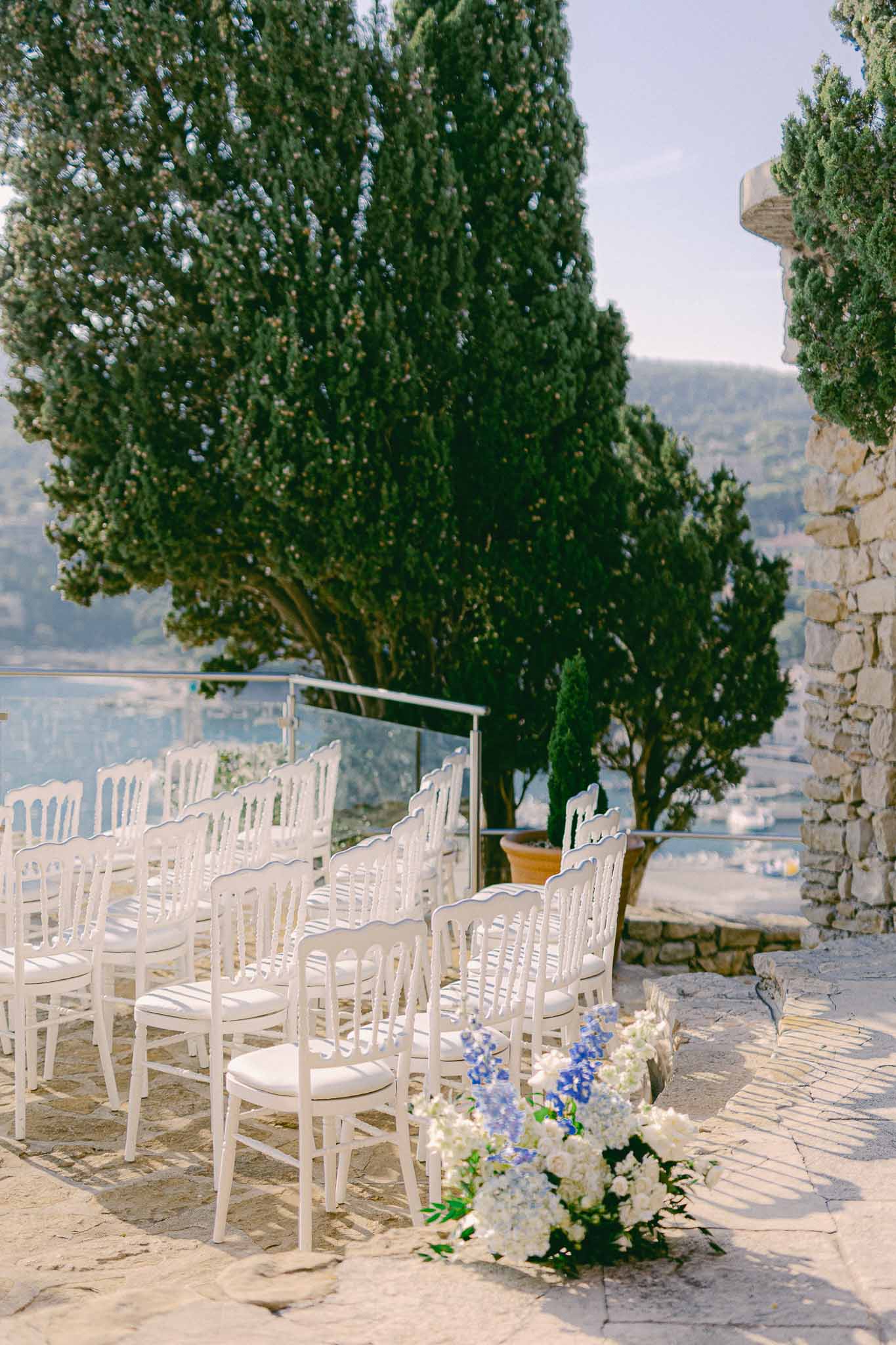 Outdoor ceremony setup on stone terrace overlooking valley at historic villa