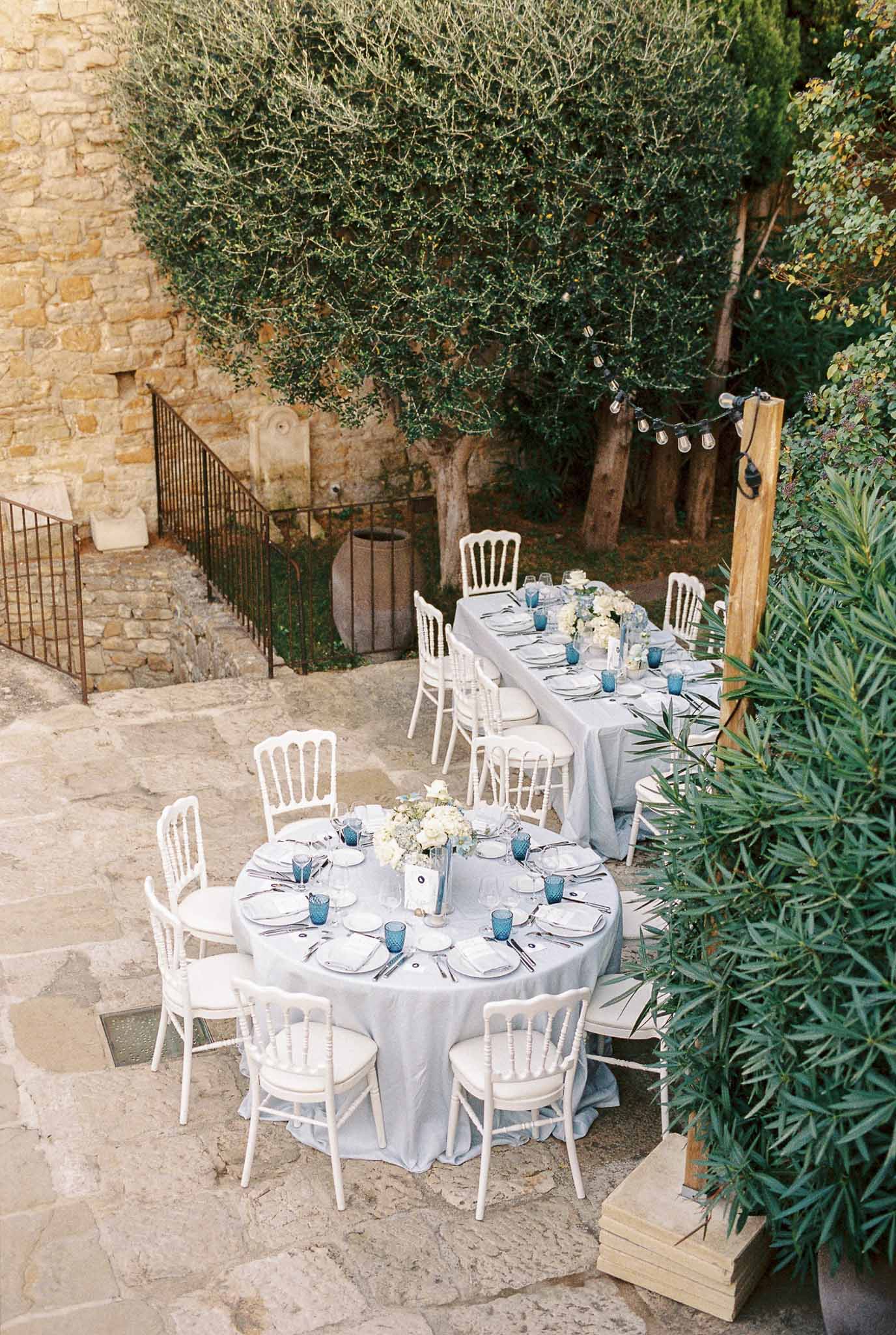Mediterranean courtyard reception setup with dining tables and string lights