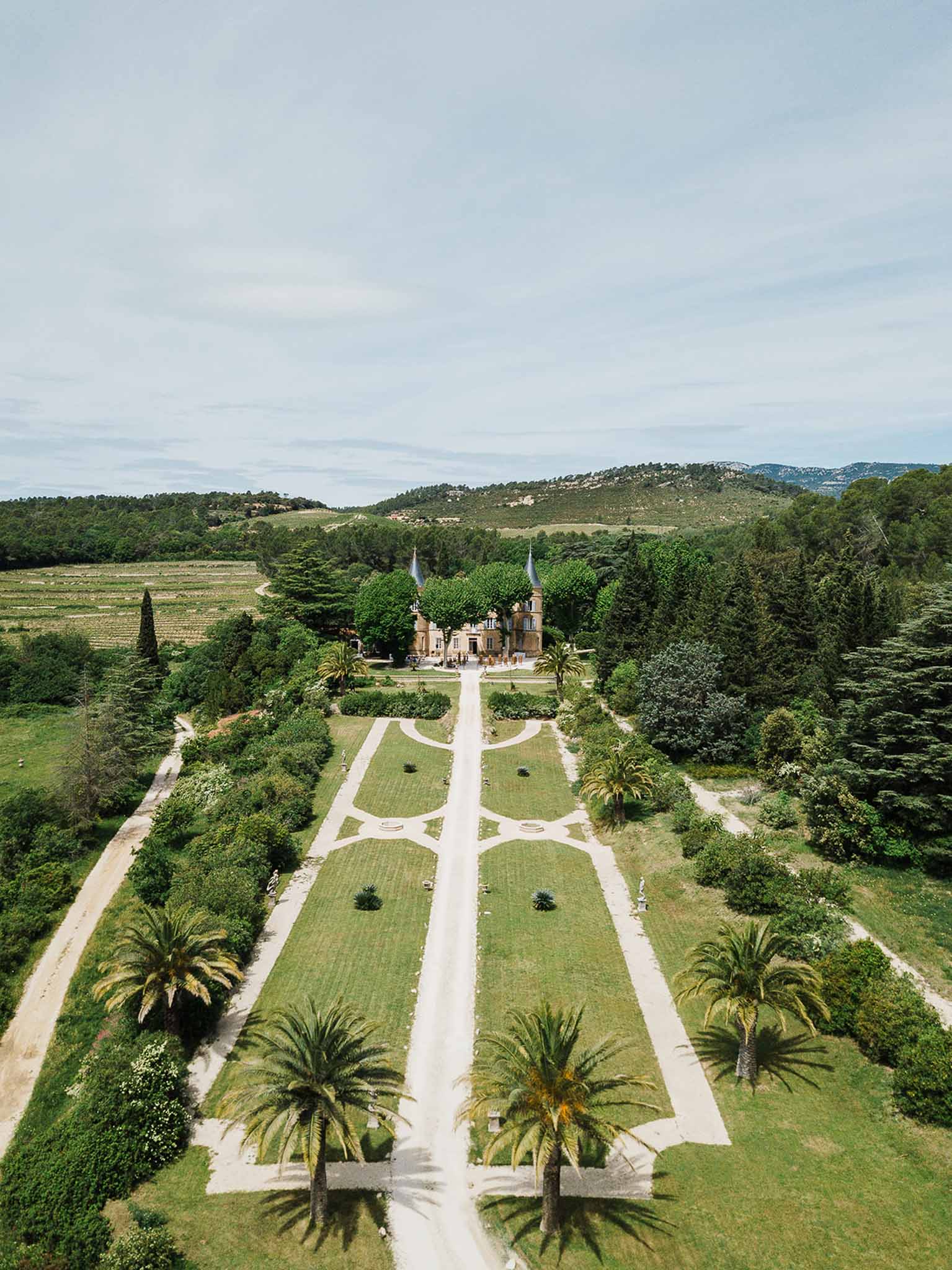 Aerial view of Tuscan villa with formal gardens and cypress-lined pathway