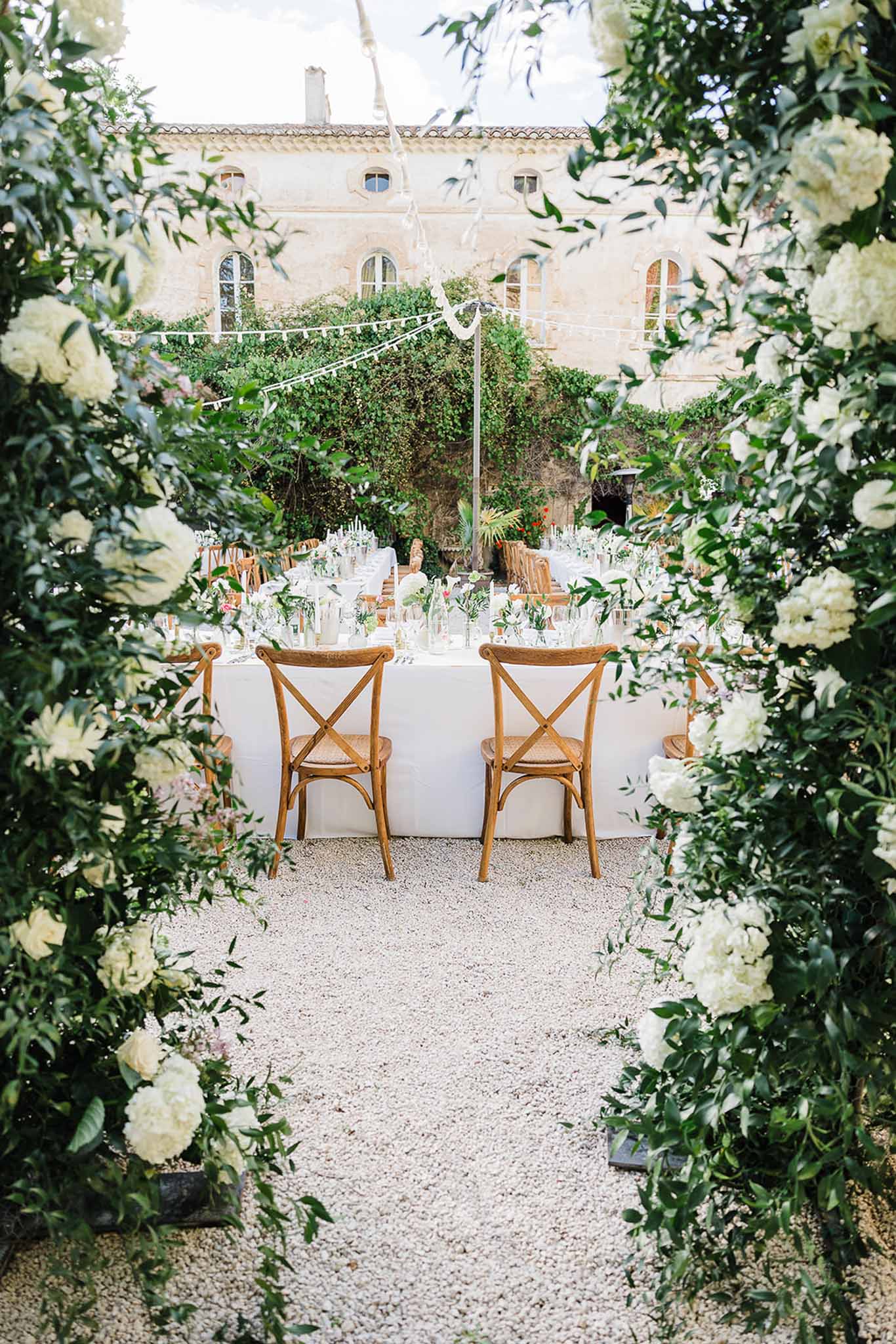 Reception courtyard framed by floral archway at Mediterranean palazzo wedding venue
