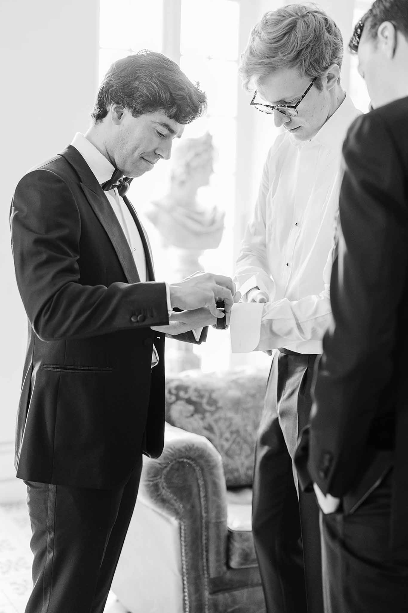 Two grooms exchanging rings during wedding ceremony in indoor venue with natural light