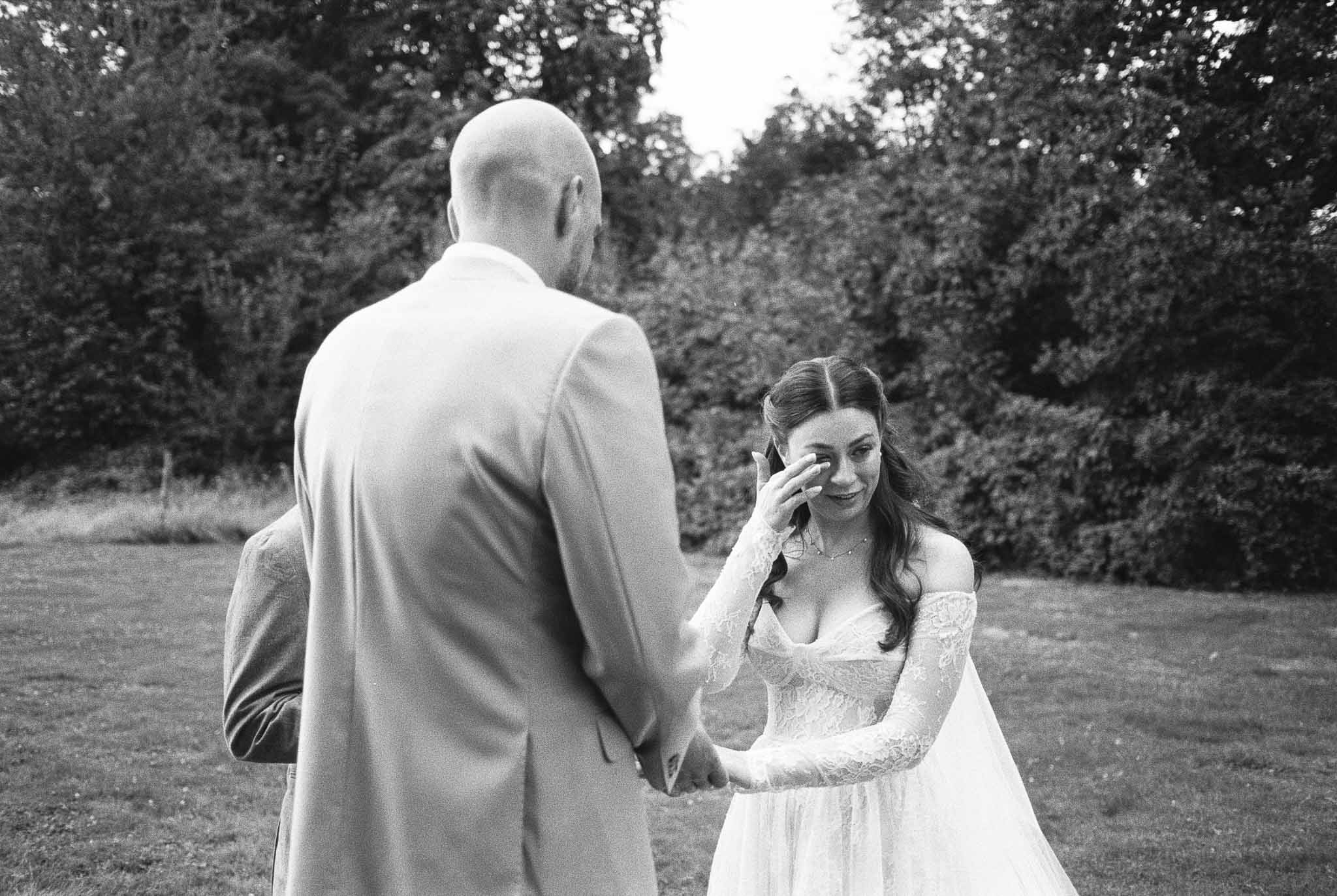 Bride and groom sharing intimate first look moment in garden setting