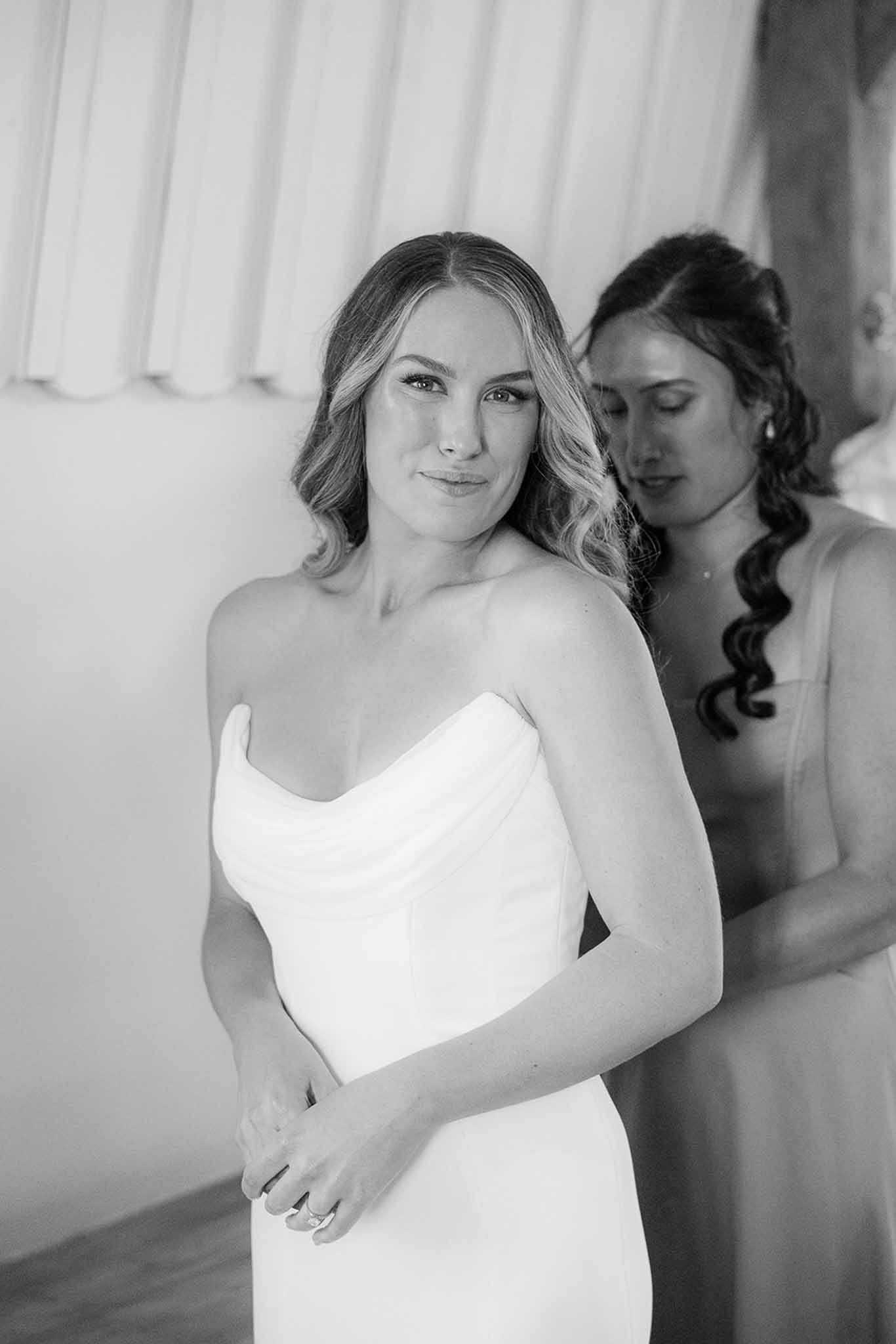 Bride and bridesmaid portrait during getting ready preparations in bridal suite with natural lighting