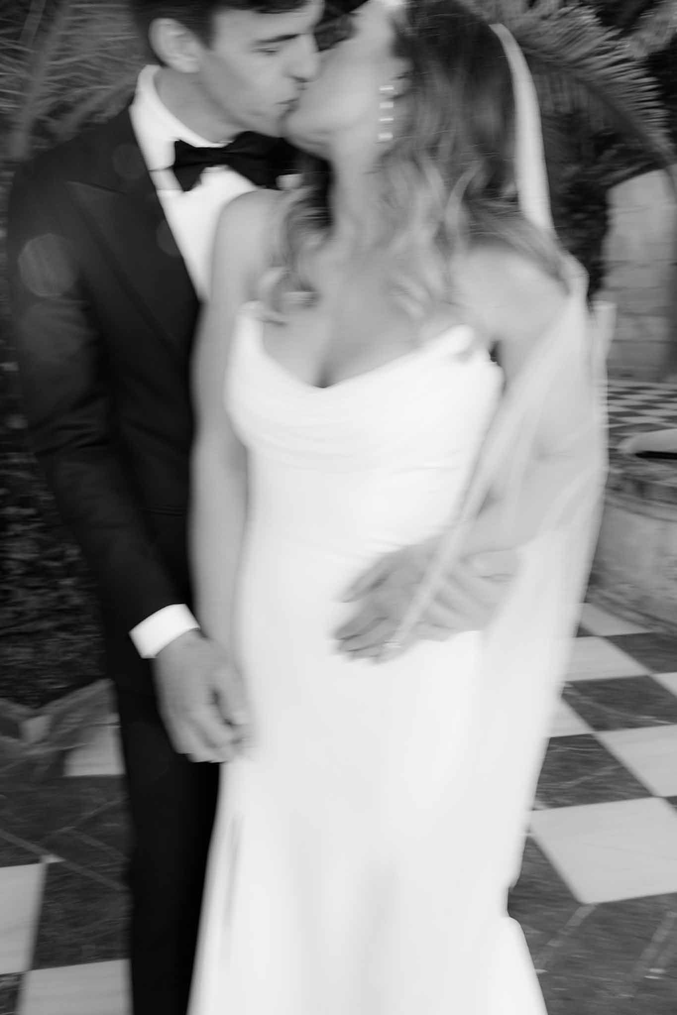 Bride and groom dancing together during first dance at wedding reception on patterned dance floor