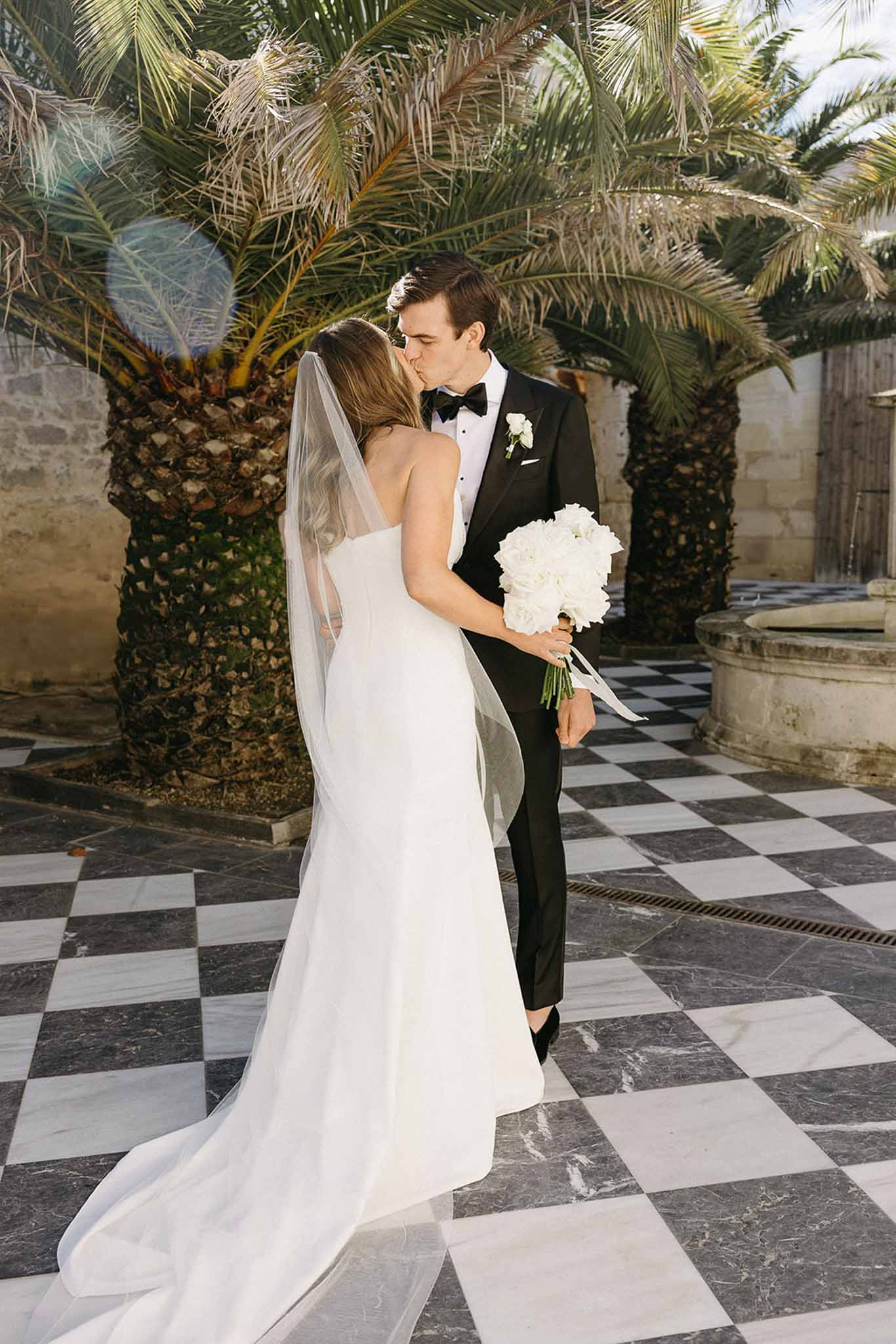 Bride and groom portrait in Mediterranean courtyard with palm trees and marble flooring