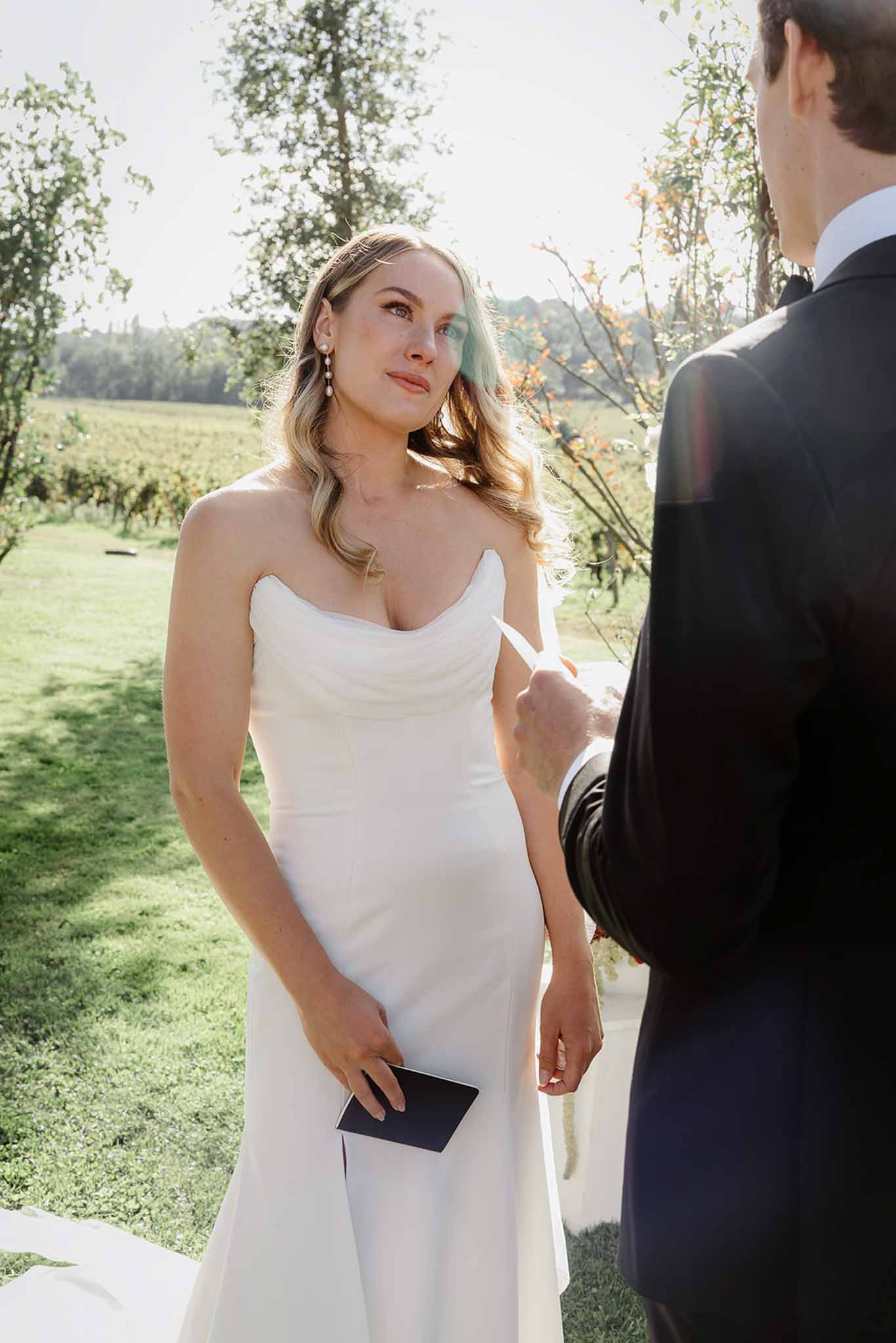 Bride and groom during outdoor vineyard ceremony with ivy and flowering vines