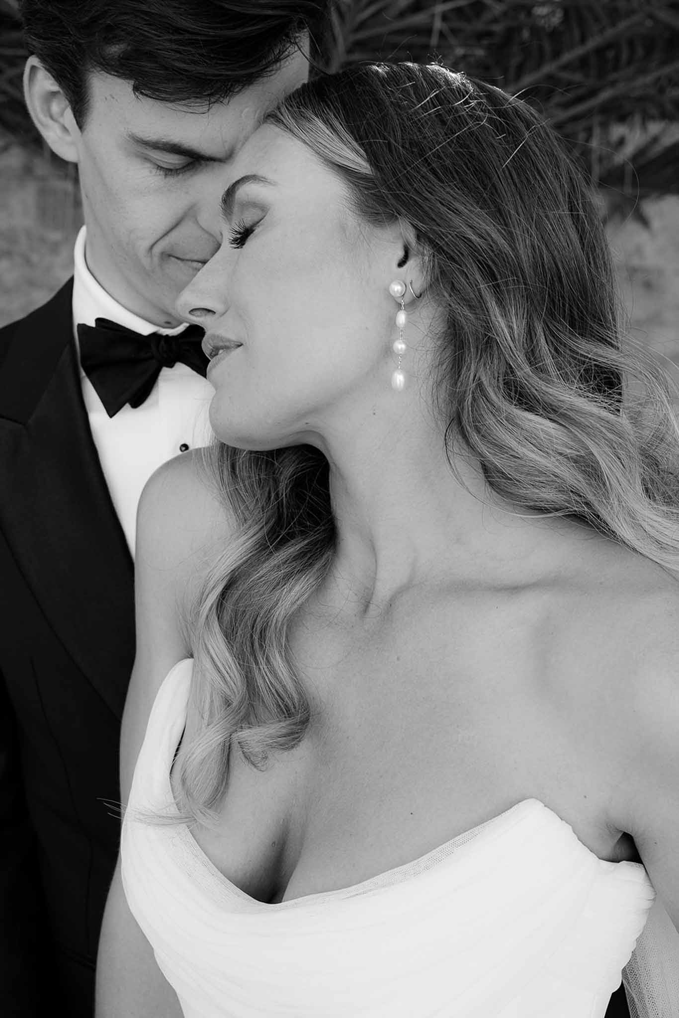 Black and white intimate portrait of bride and groom in tender moment at wedding