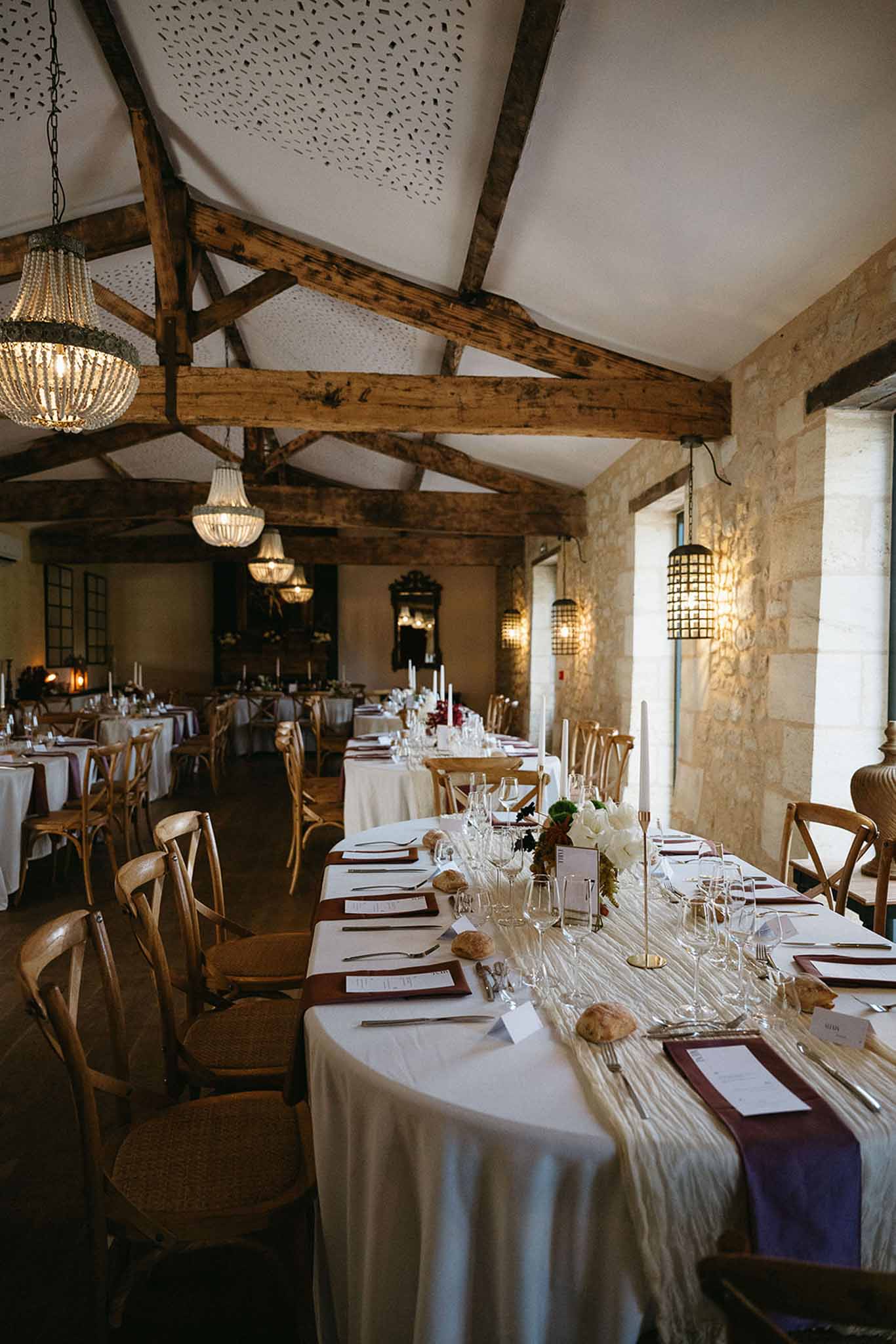 Formal reception dining room with exposed beams and elegant table settings at rustic-modern venue