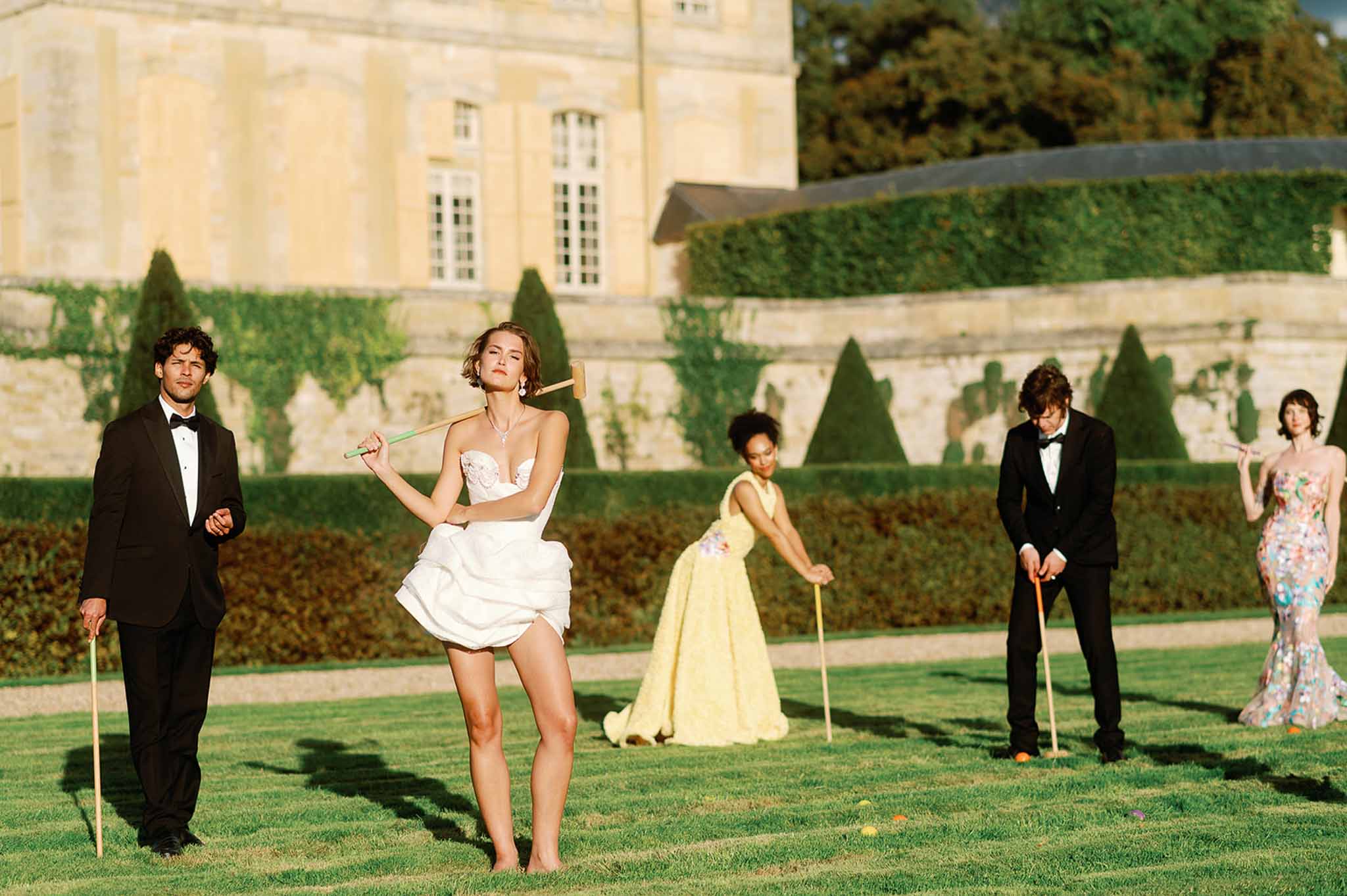 Wedding guests playing croquet on château grounds during reception