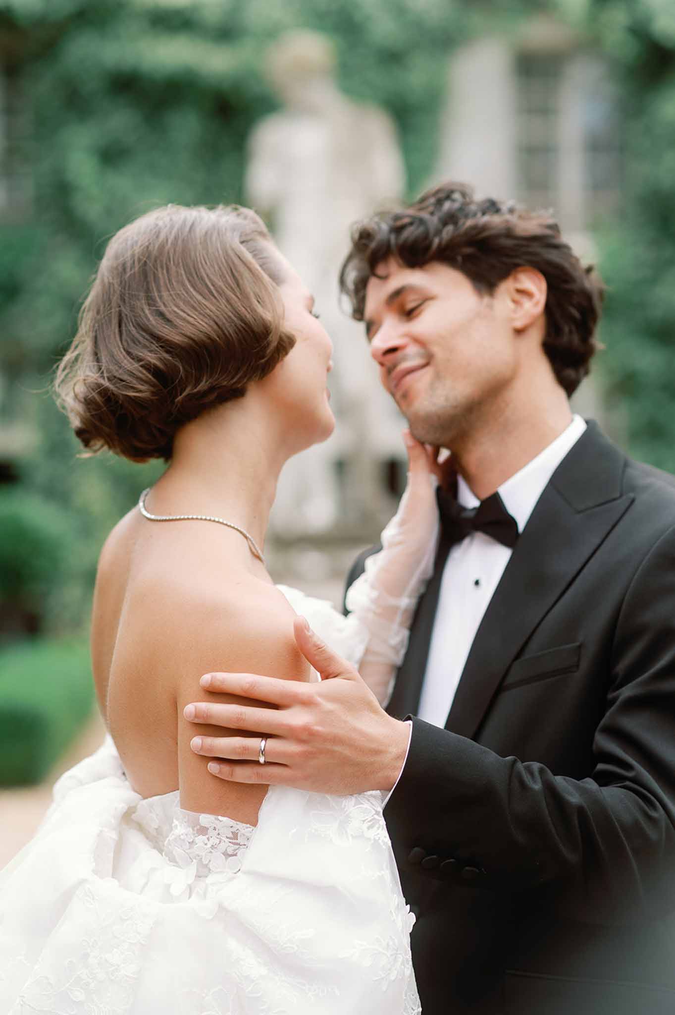 Bride and groom in intimate portrait pose in formal garden setting