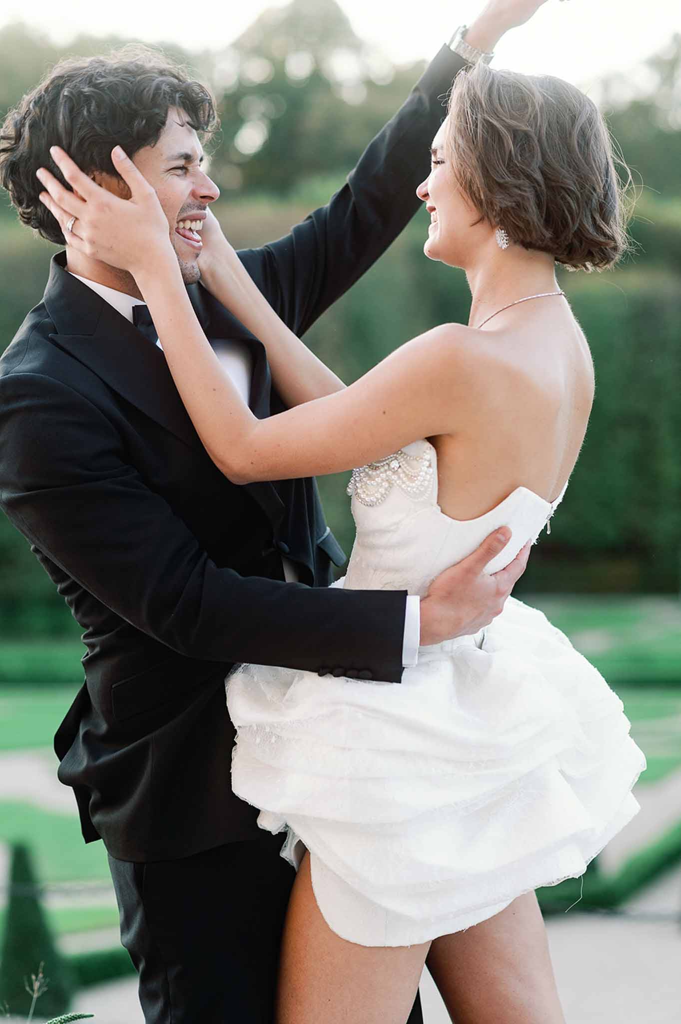 Happy couple embracing in garden setting after wedding ceremony