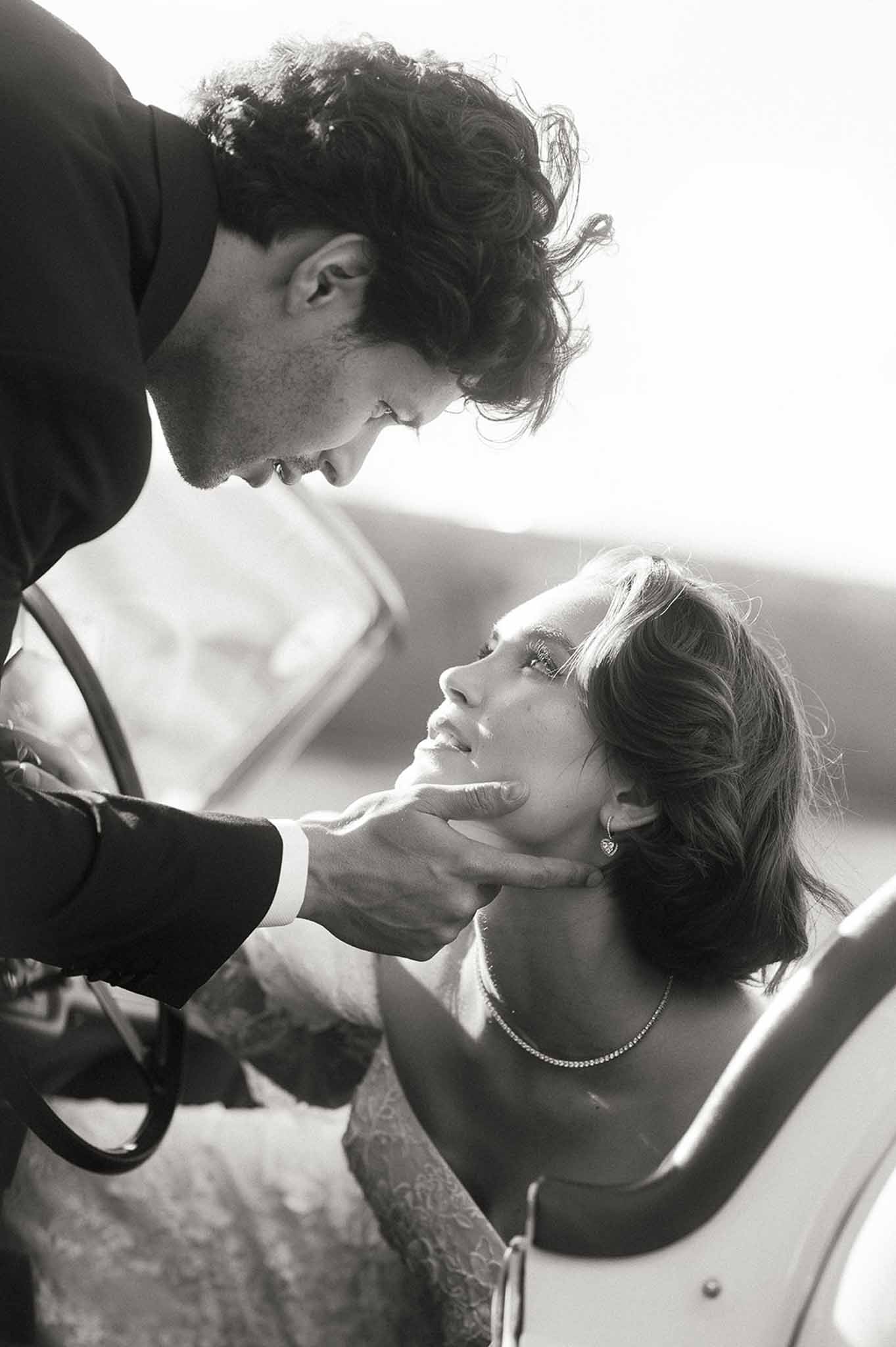 Intimate black and white portrait of bride and groom in tender moment after wedding ceremony