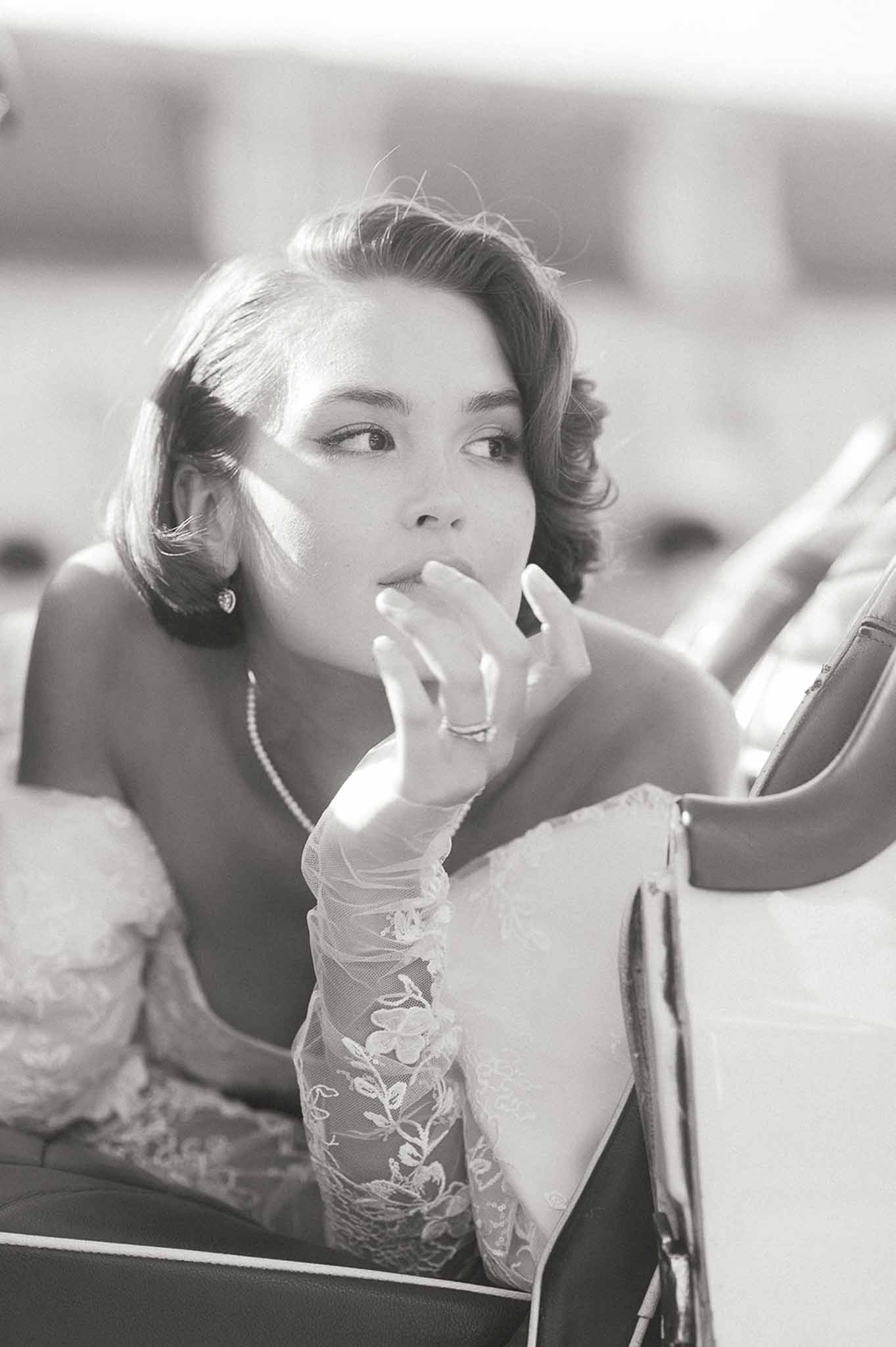 Bride applying lipstick in mirror during getting ready preparation in bridal suite