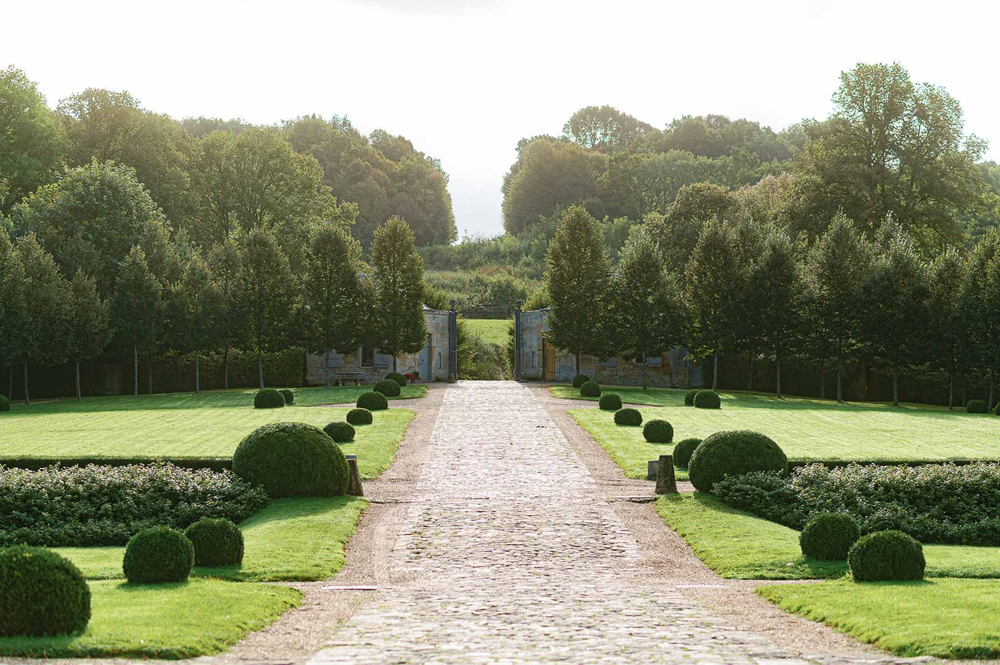 Formal garden pathway with stone gate at grand estate wedding venue