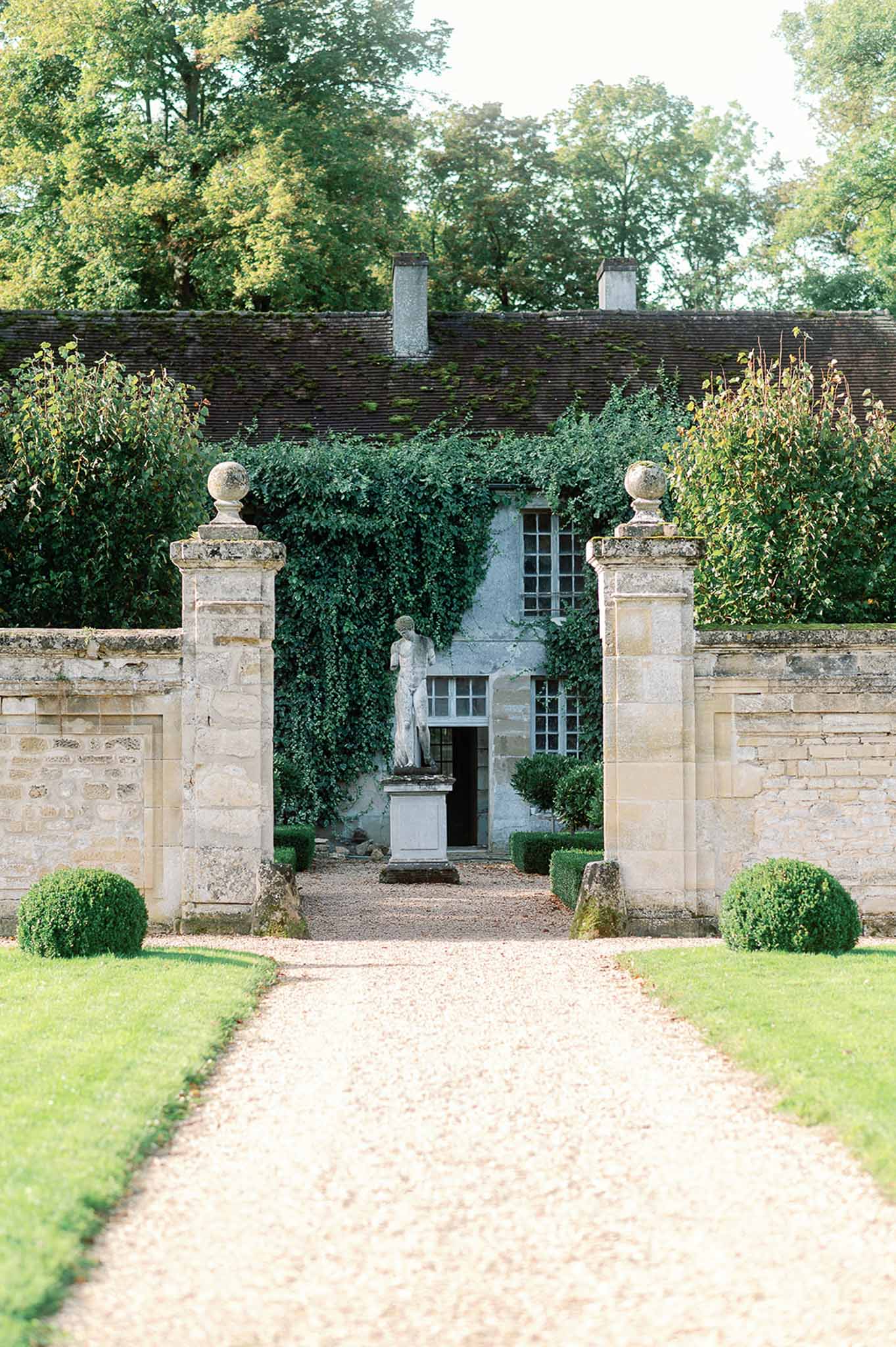 Stone gatehouse entrance with gravel pathway at classical country estate venue