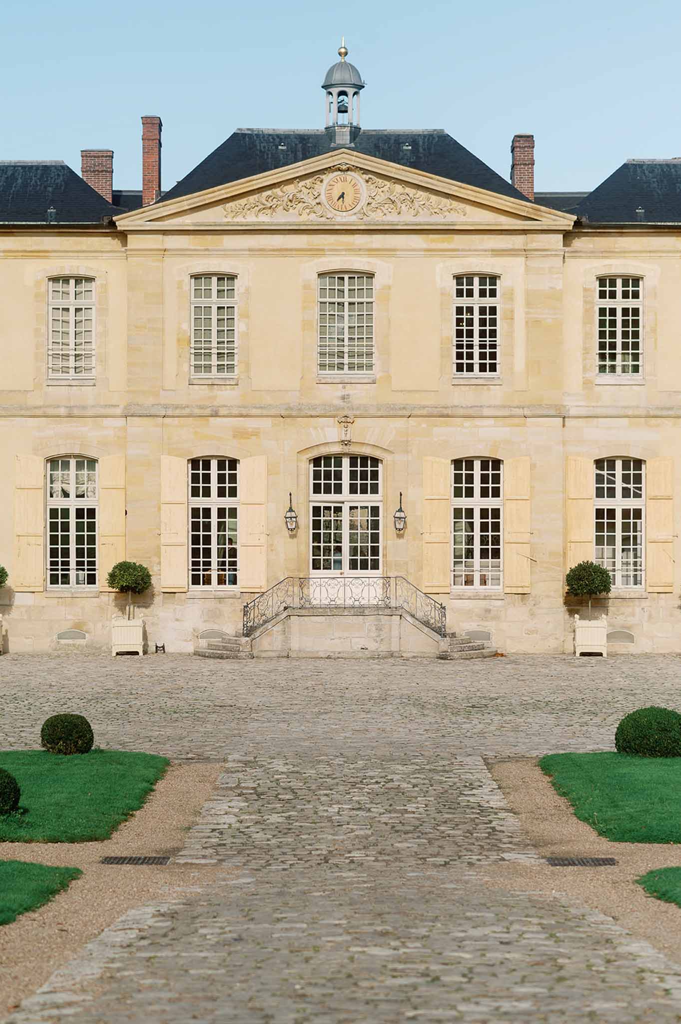 Classical French château facade with formal courtyard and manicured gardens