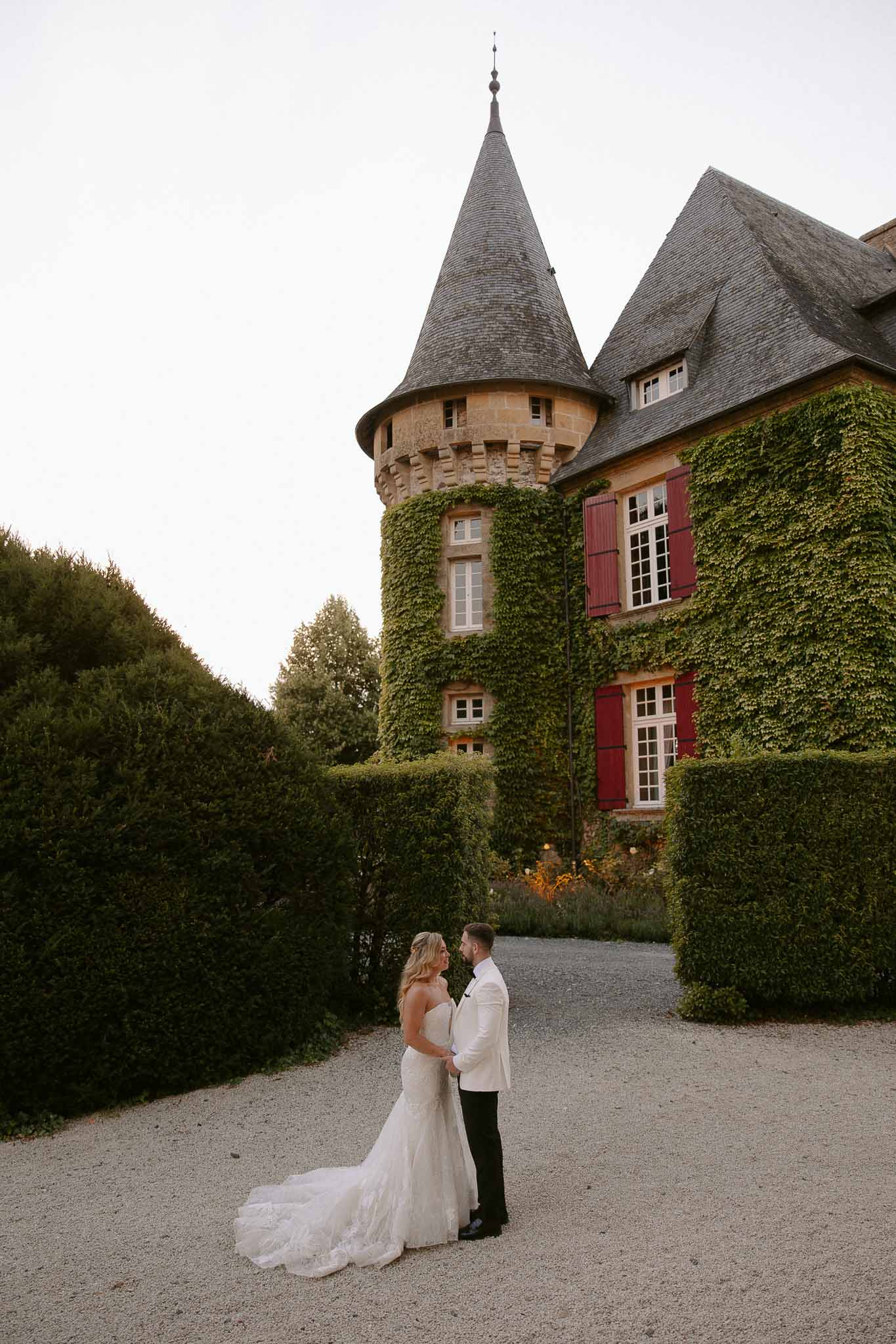 Bride and groom portrait on gravel courtyard pathway at French château wedding venue