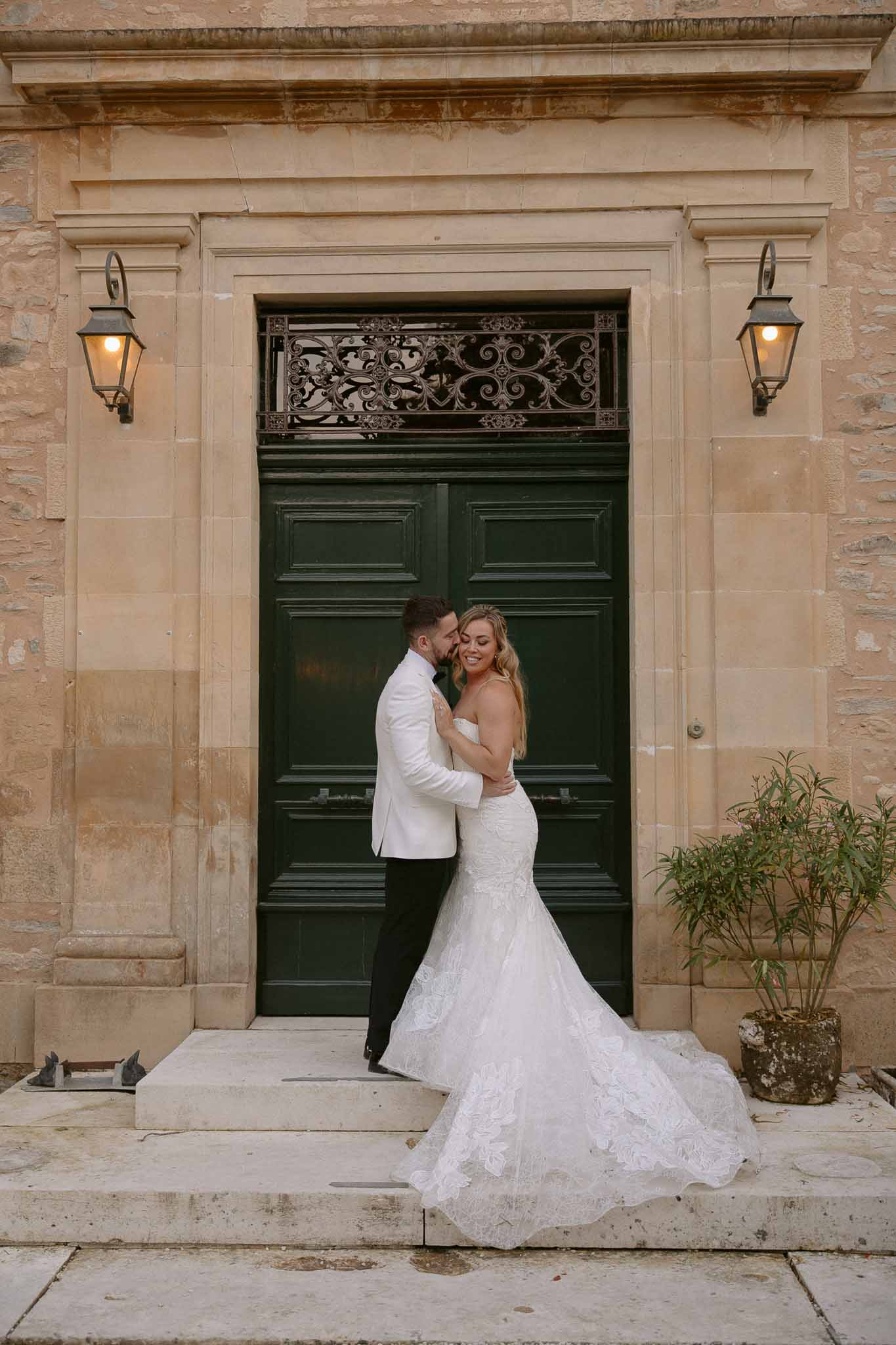 Bride and groom portrait in front of classical stone building with green door