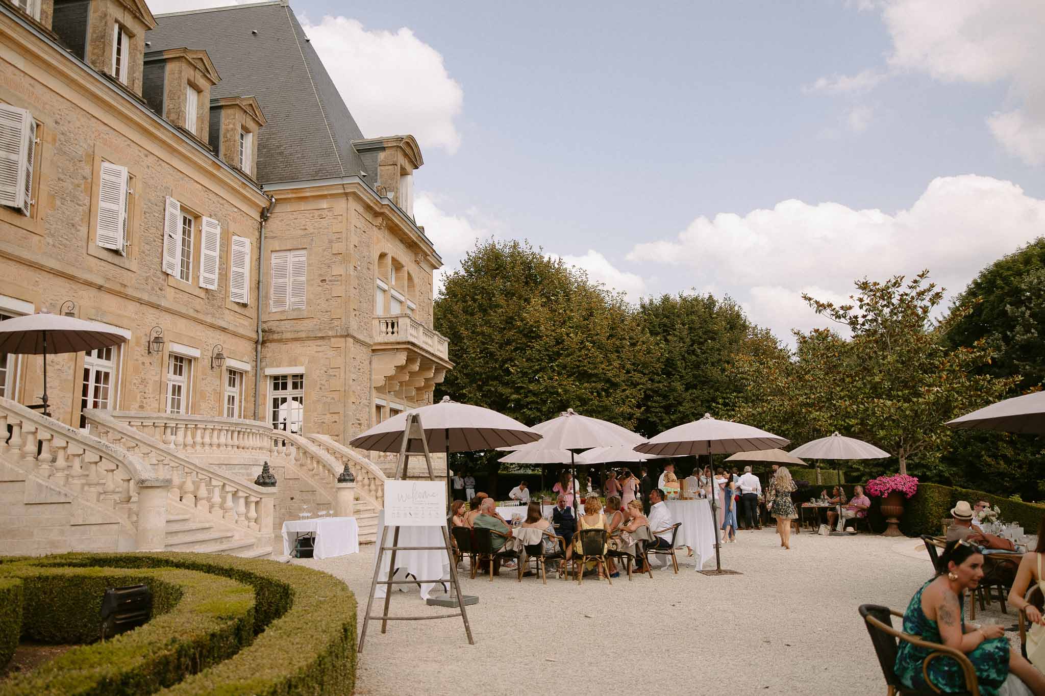 Cocktail hour reception with guests on château terrace courtyard