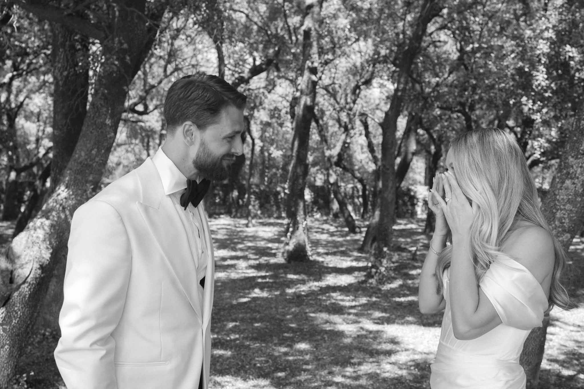 Bride and groom intimate portrait in tree-lined avenue at outdoor wedding venue