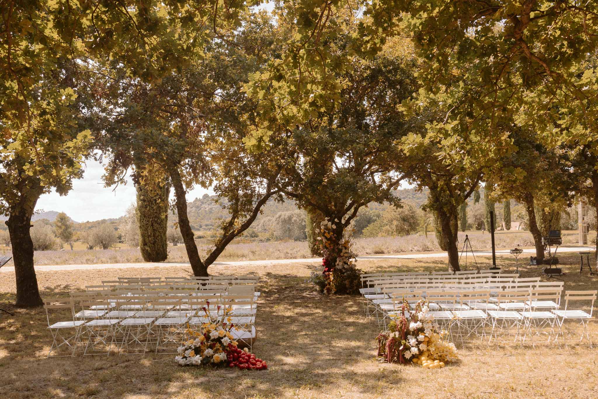 Outdoor ceremony setup under cypress trees at Mediterranean countryside estate