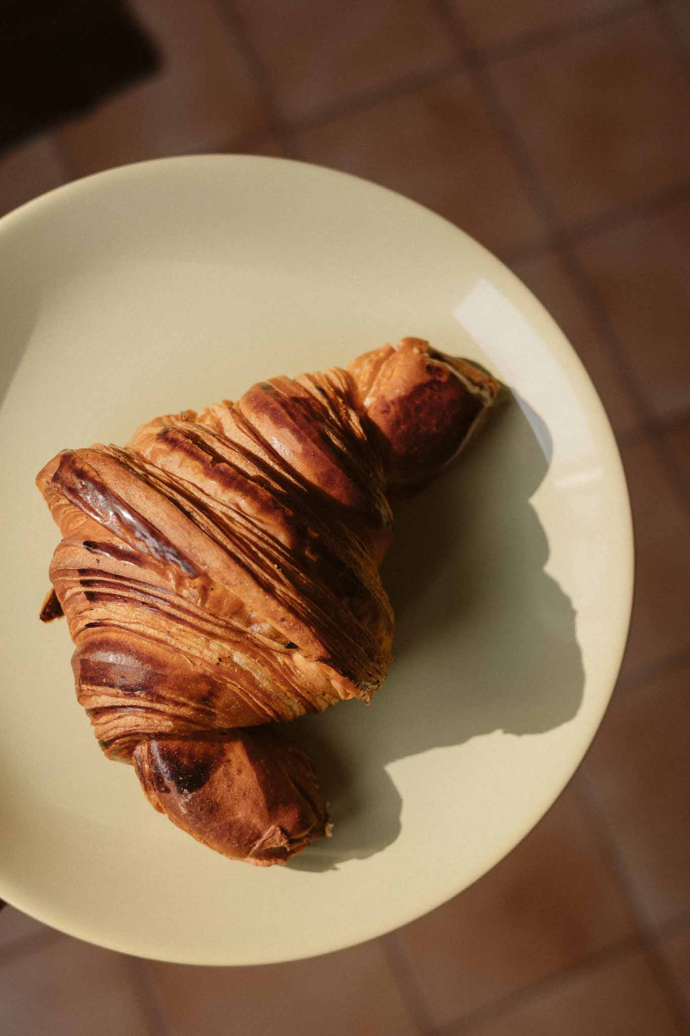 Chocolate croissant on ceramic plate for wedding breakfast service