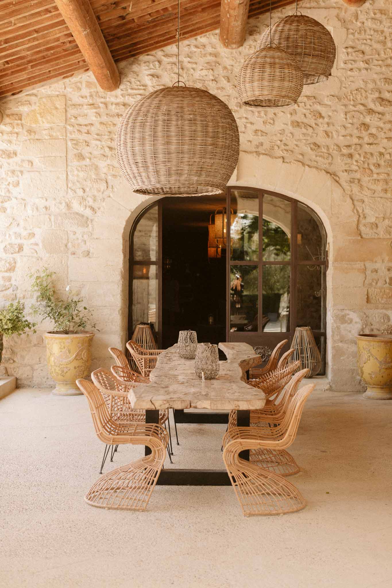 Rustic dining room with stone walls and woven pendant lights at bohemian wedding venue