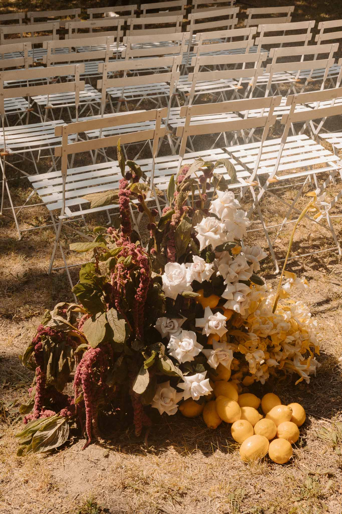 Autumn floral arrangement with ceremony seating at outdoor wedding venue