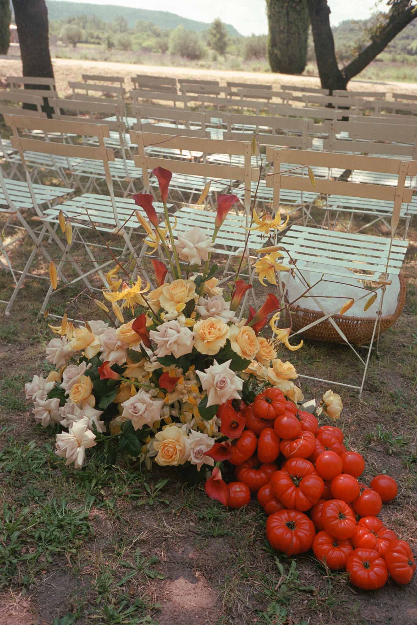 Outdoor ceremony setup with floral arrangements and wooden chairs in Mediterranean landscape