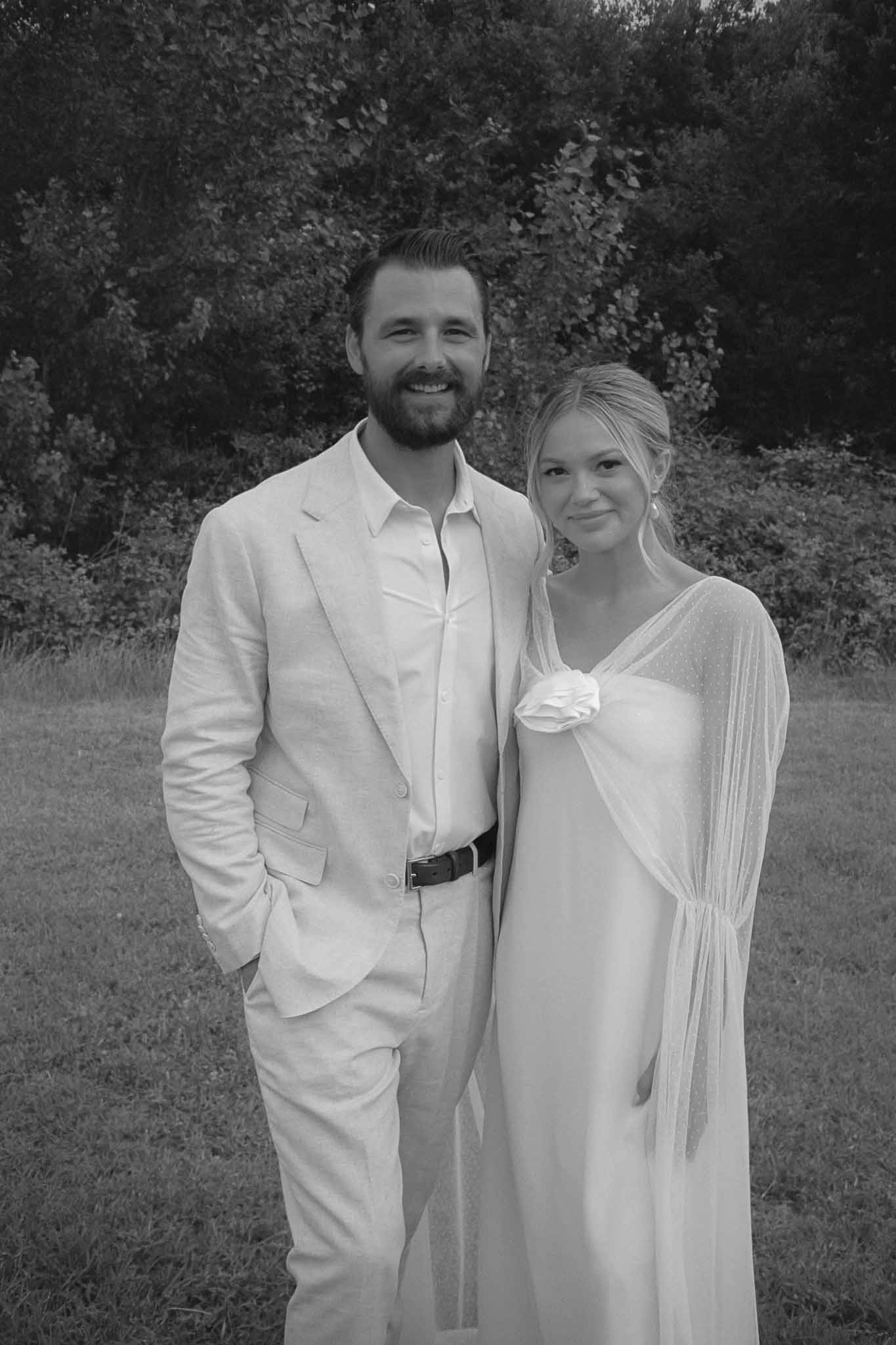 Black and white couple portrait outdoors with hedge backdrop at wedding venue