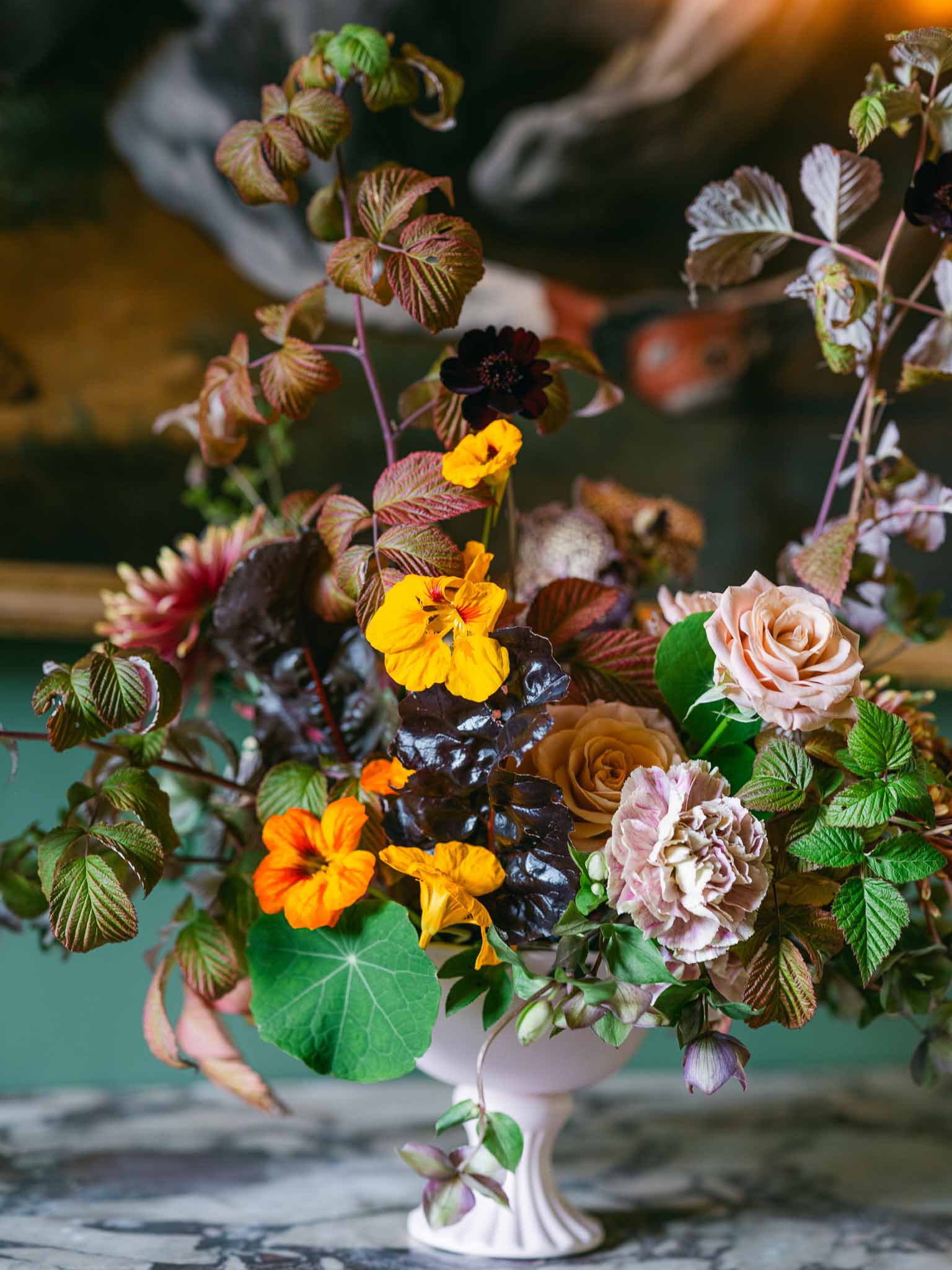 Bridal centerpiece arrangement with roses, peonies, and dahlias in white ceramic pitcher
