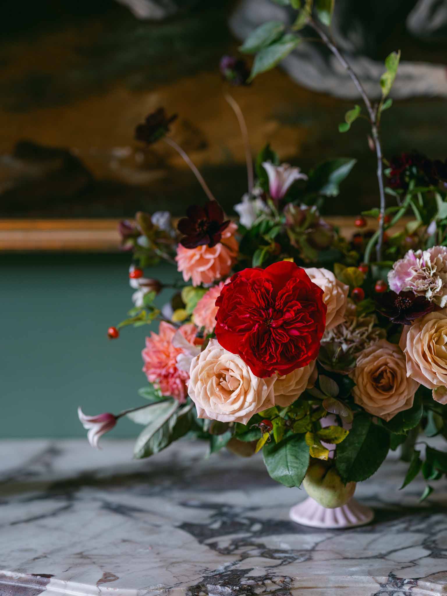 Close-up floral arrangement with roses and eucalyptus in ceramic urn for garden wedding