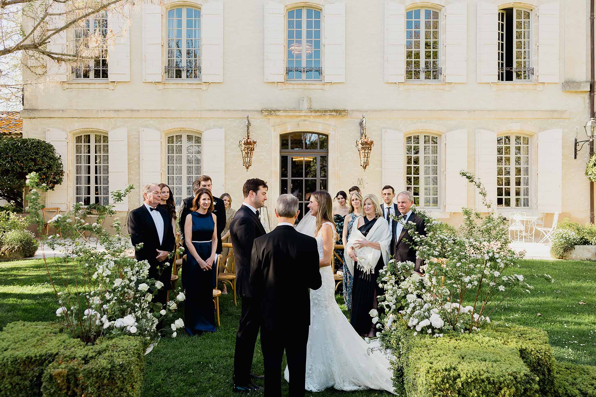 Wedding ceremony in courtyard of French château with bride, groom and guests
