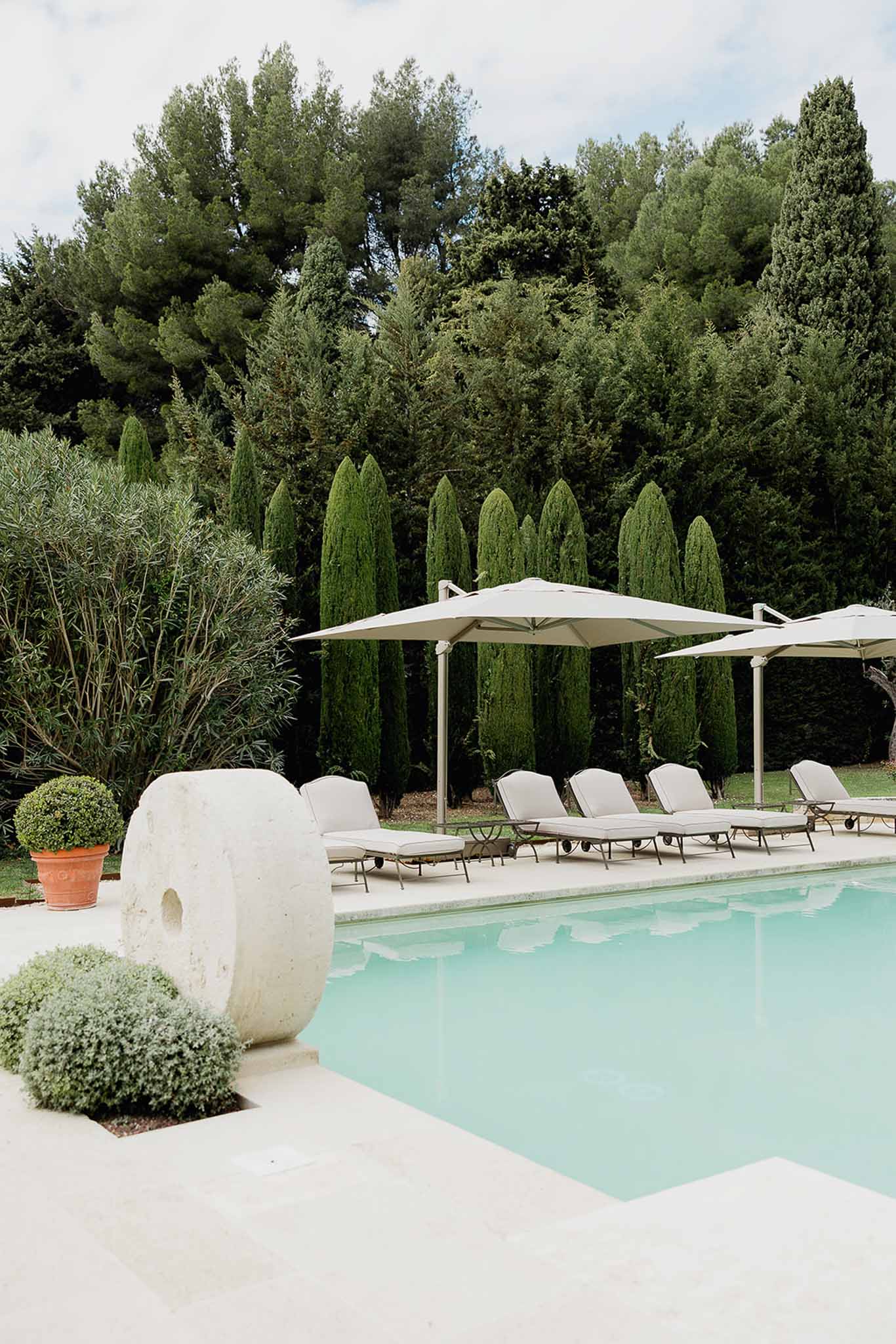 Poolside wedding venue terrace with lounge chairs and Mediterranean landscaping