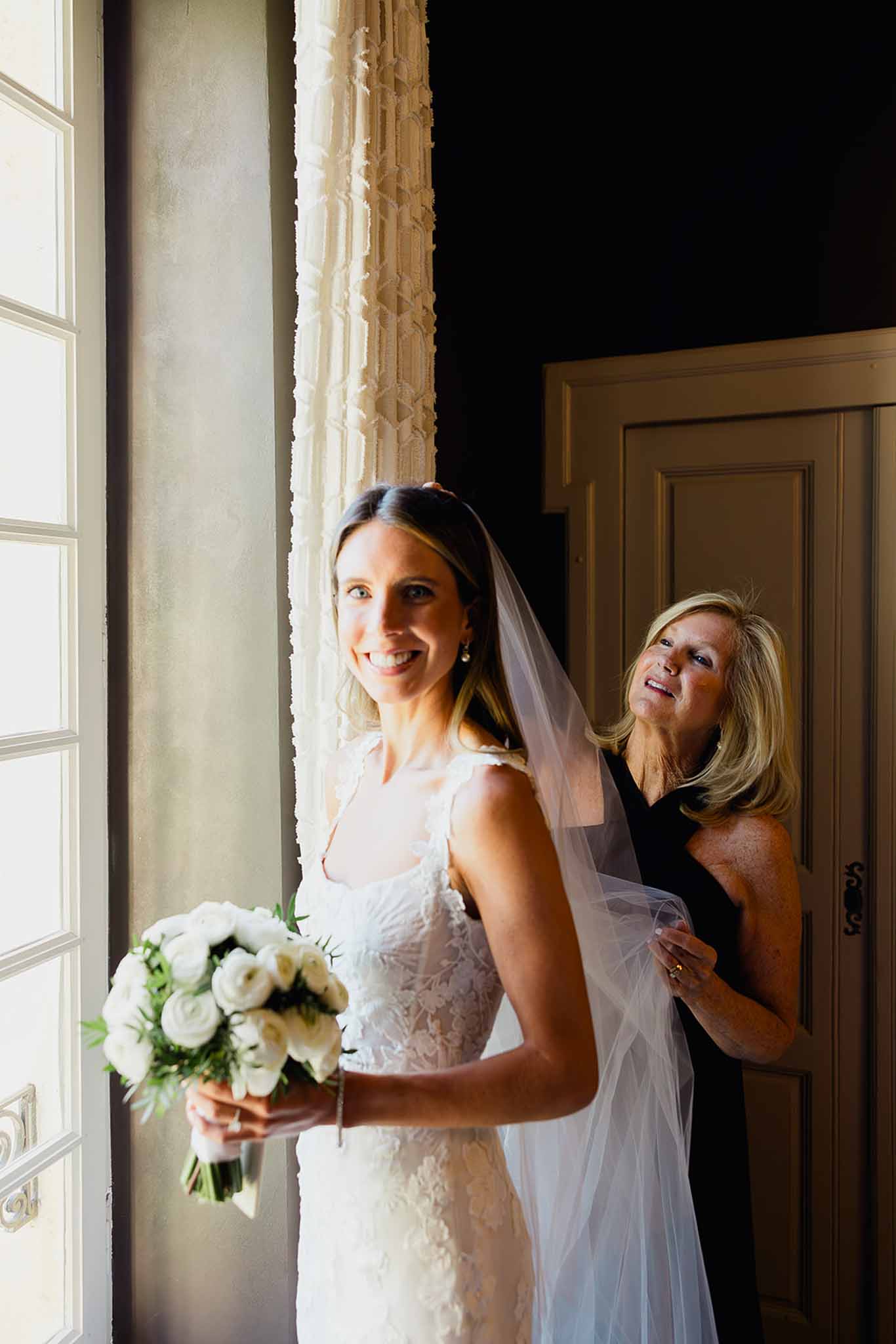 Bride with mother in elegant hallway during wedding preparations