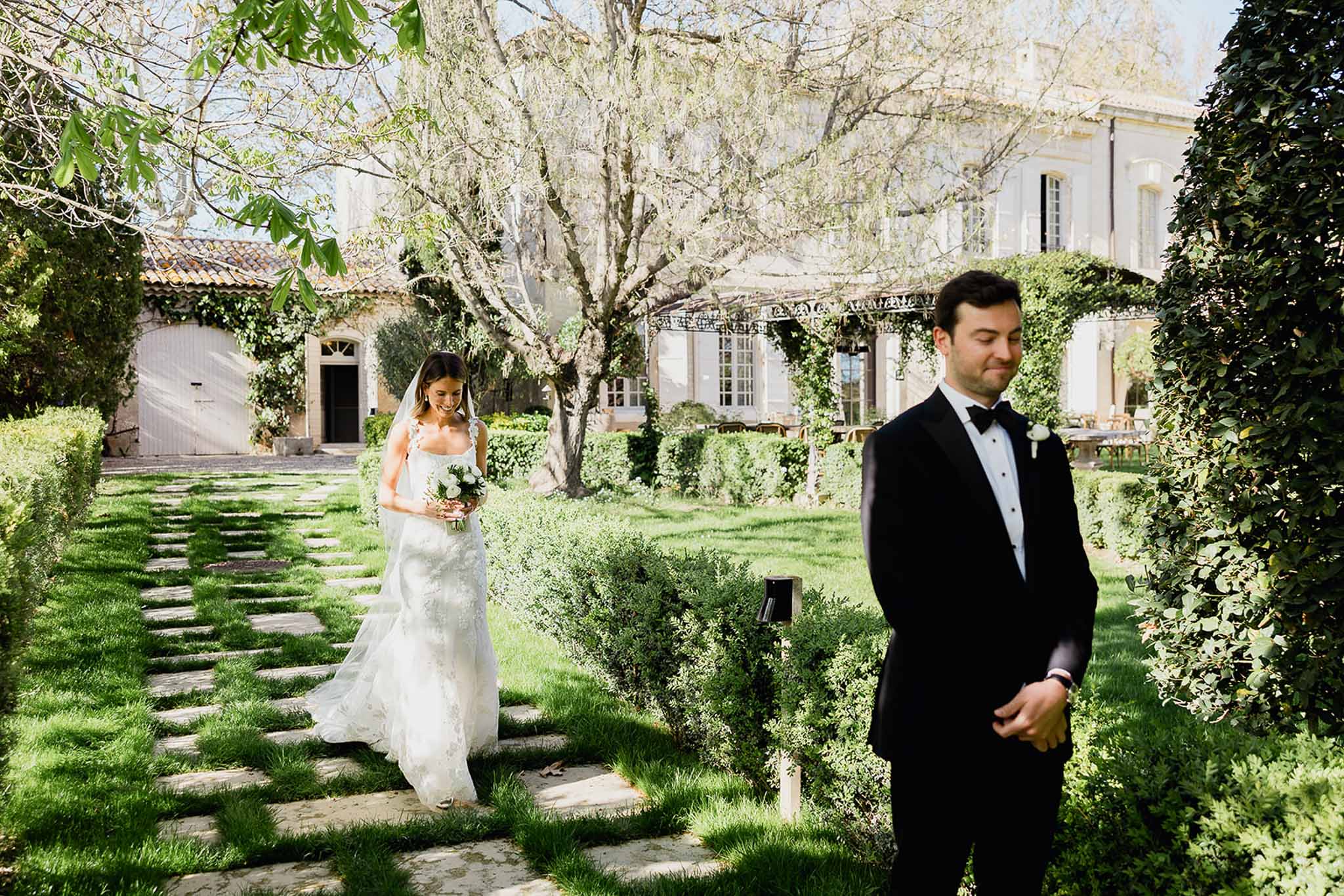 Bride and groom first look moment in European estate garden courtyard with classical architecture