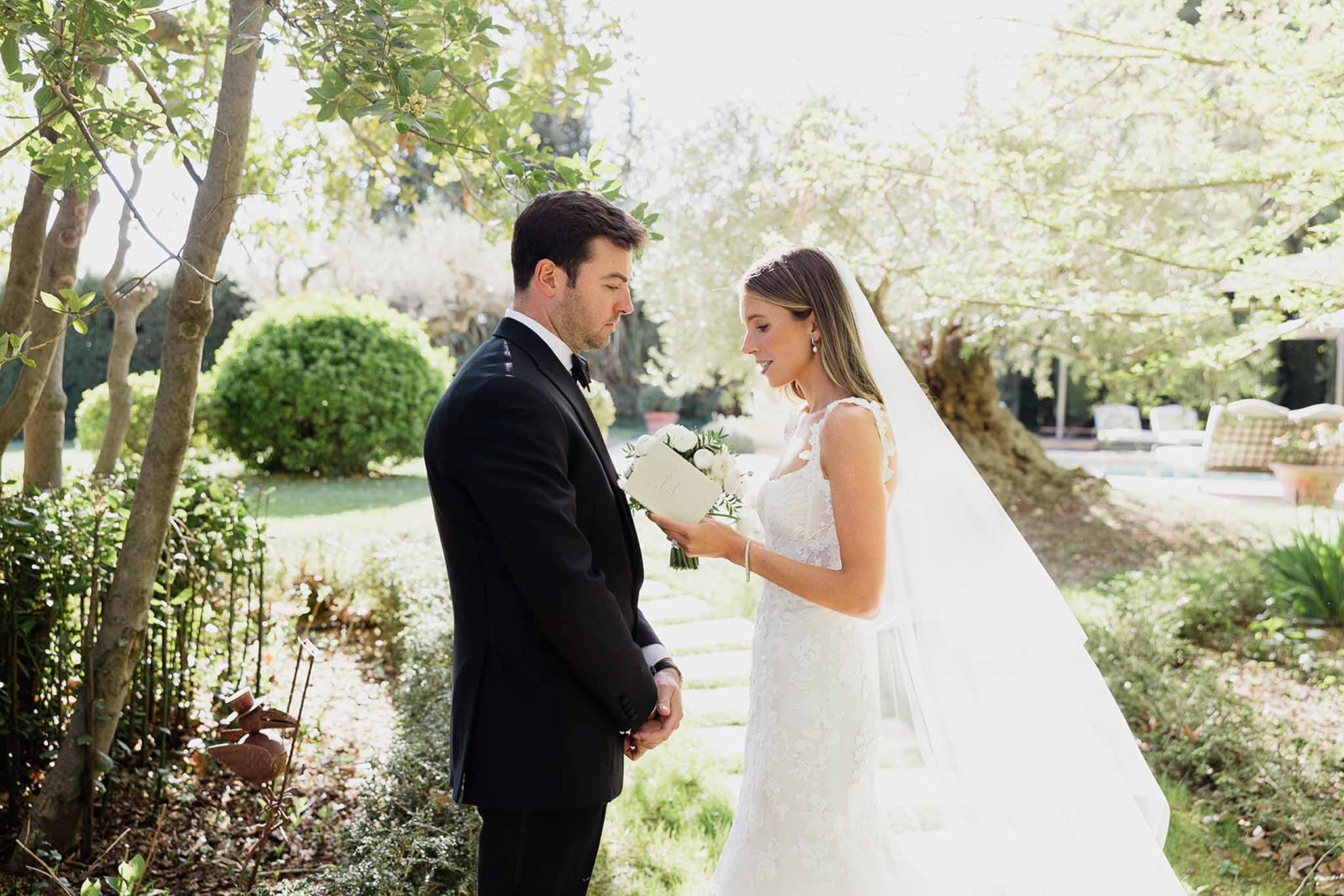 Bride and groom sharing intimate moment in formal garden setting with natural lighting