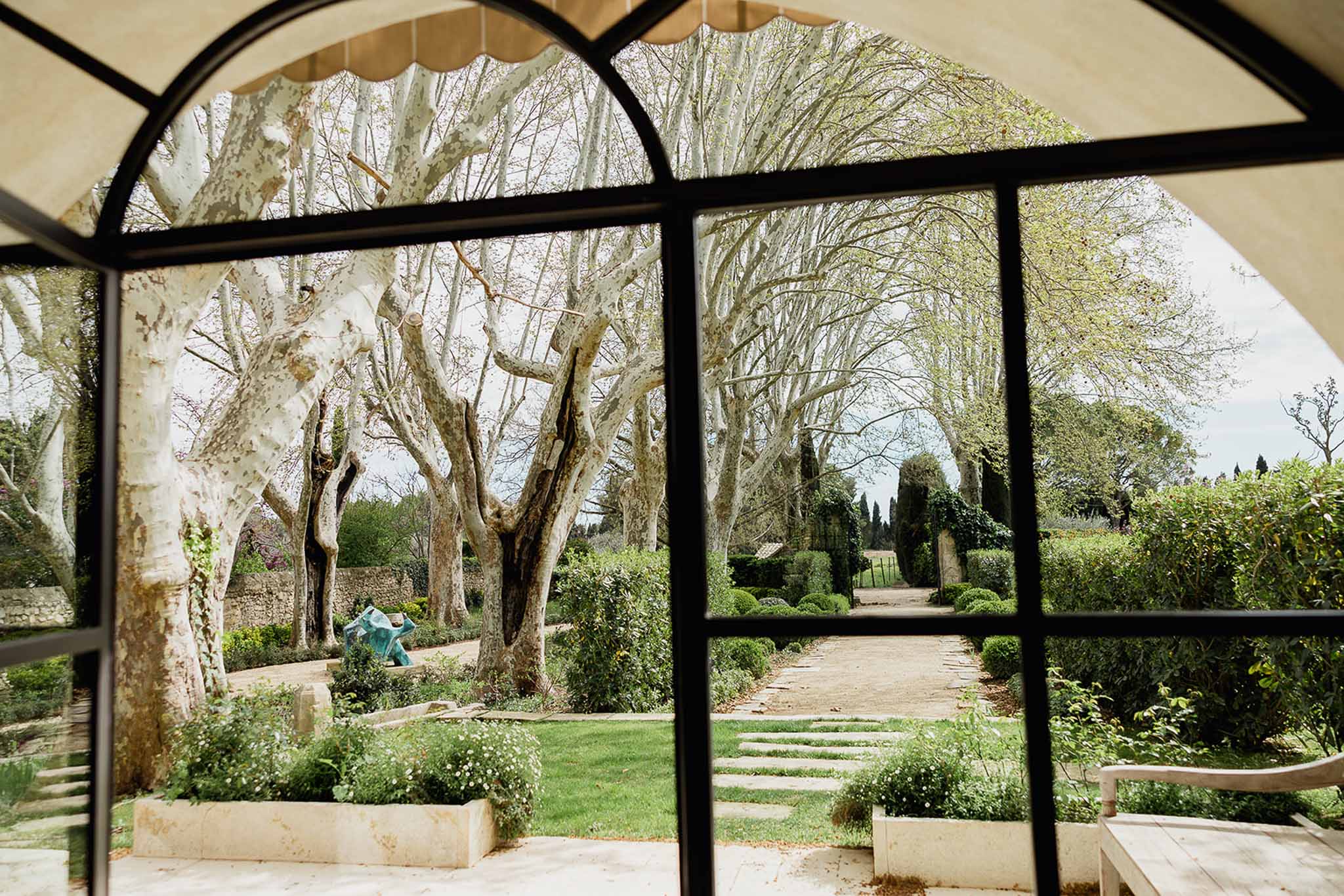 Formal garden grounds viewed through pavilion windows at wedding venue