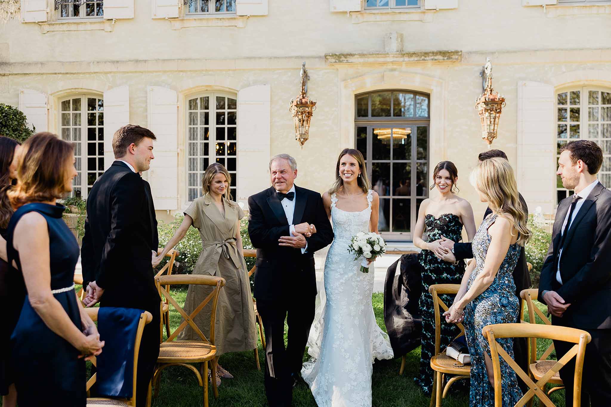 Bride and groom greeting guests during cocktail hour on manor house lawn