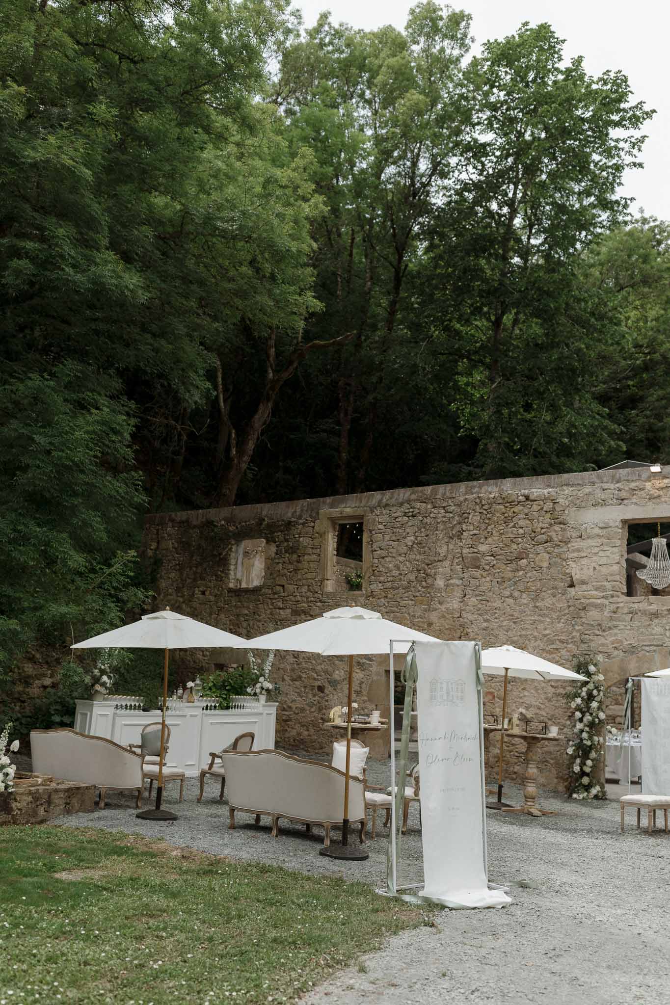 Cocktail lounge area with umbrellas and seating in stone courtyard at historic venue