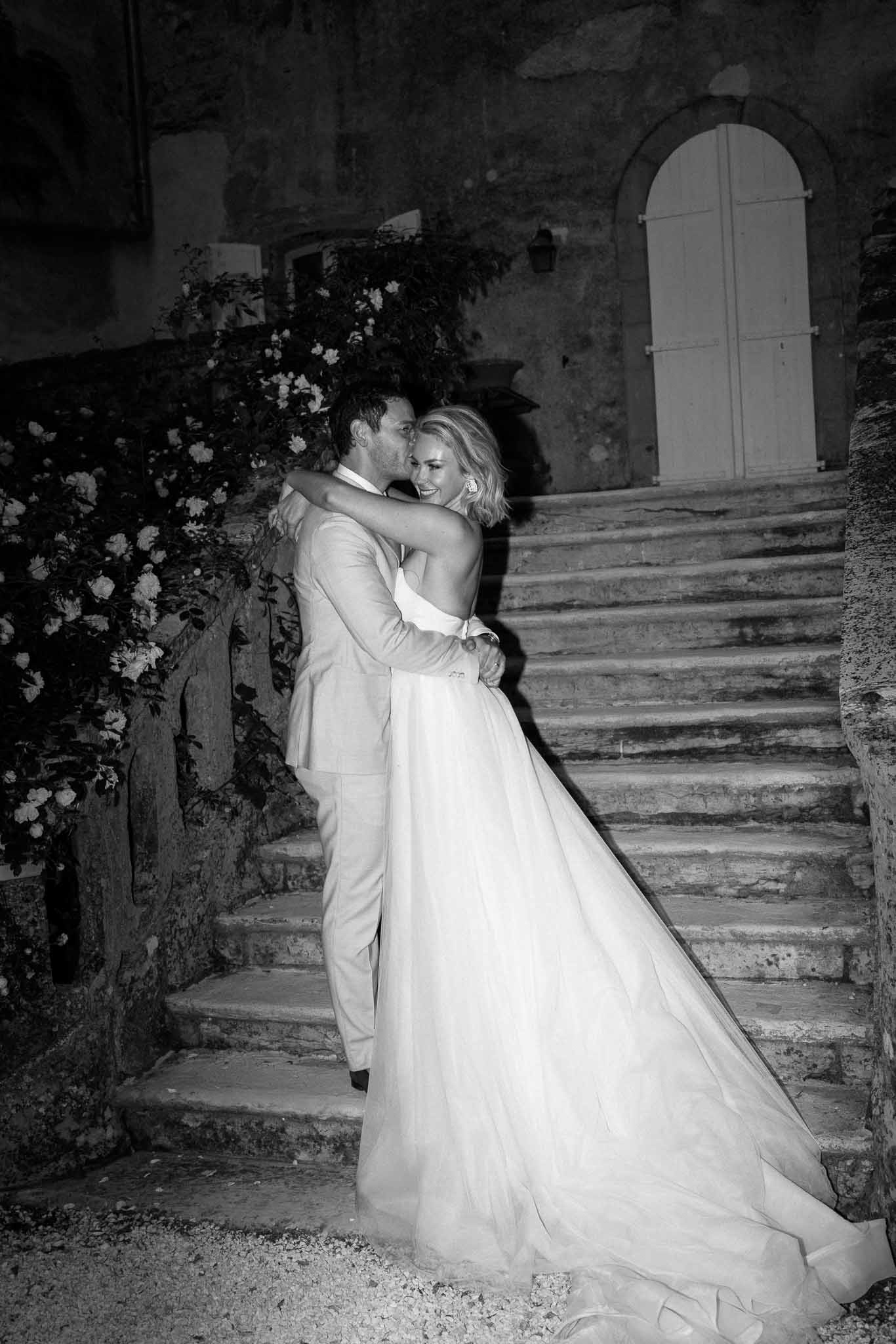 Bride and groom in romantic pose on stone staircase at historic venue