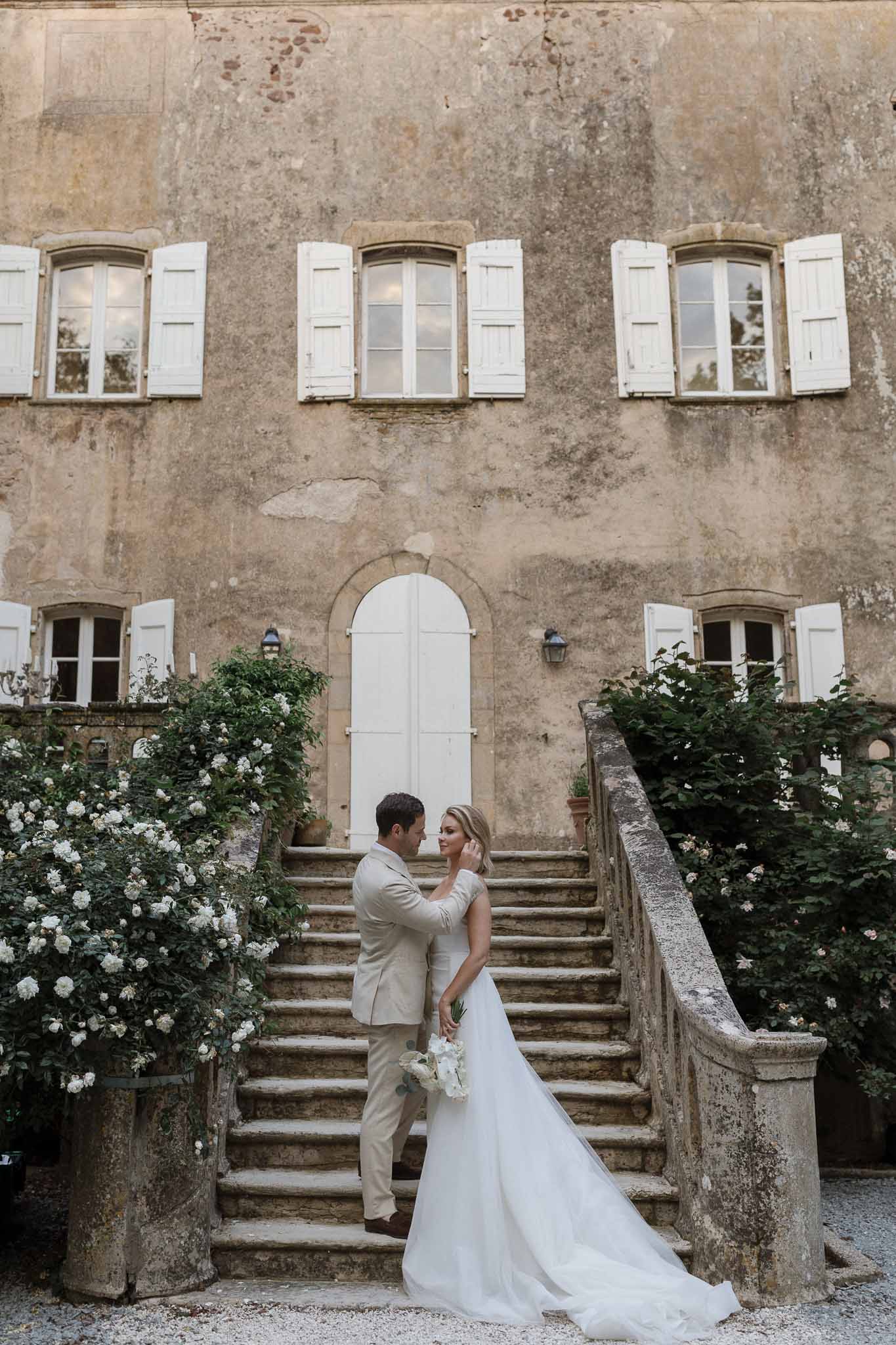 Bride and groom formal portrait on stone staircase at historic European venue