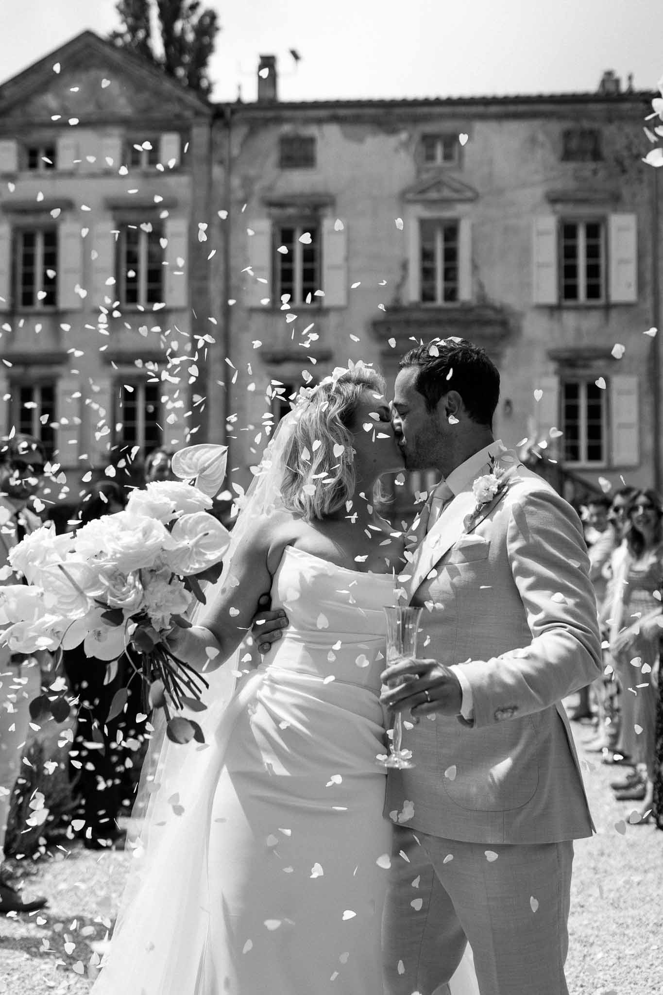 Newlyweds' petal toss exit at grand neoclassical estate courtyard