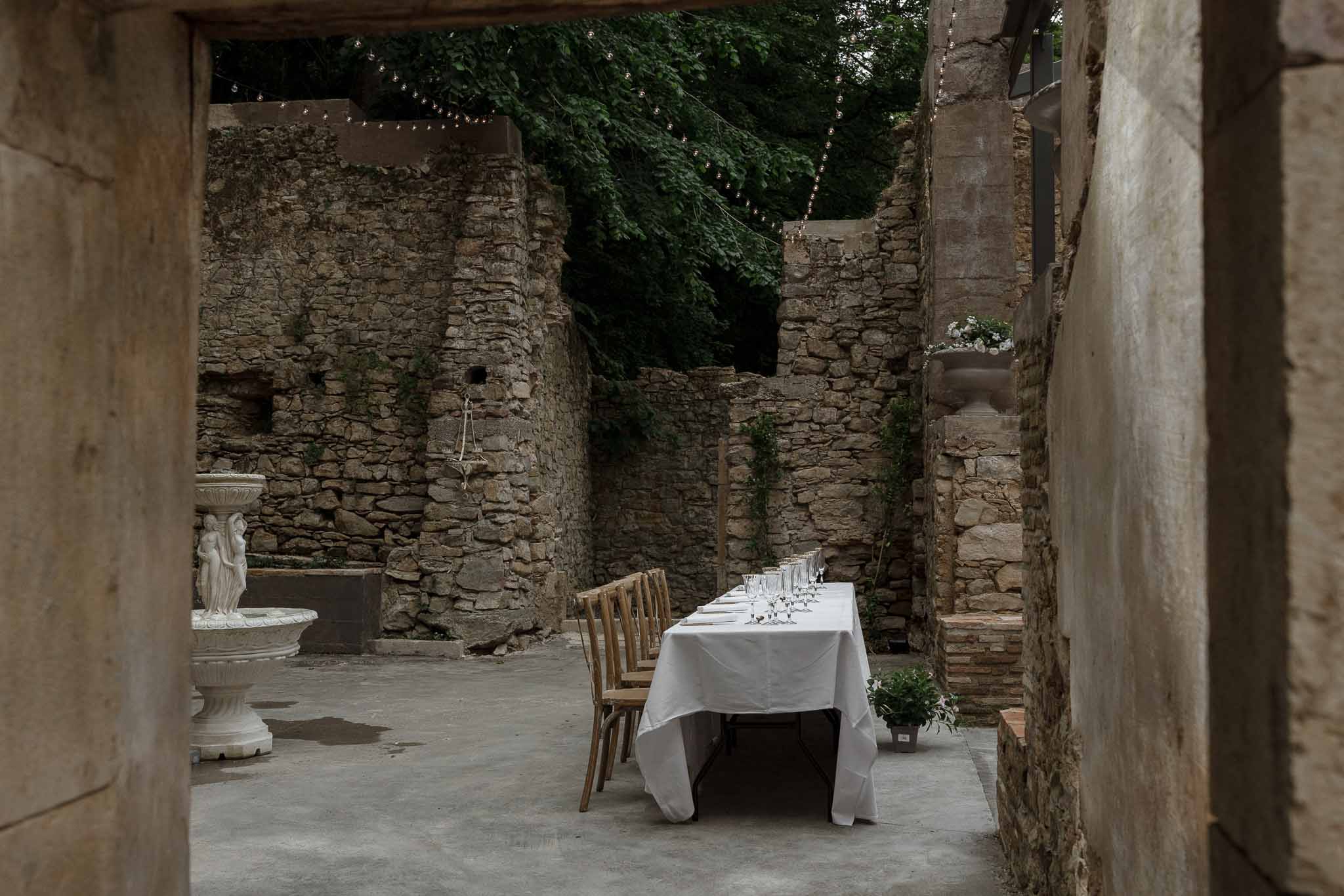 Sweetheart table setup in historic stone courtyard with archways and string lights