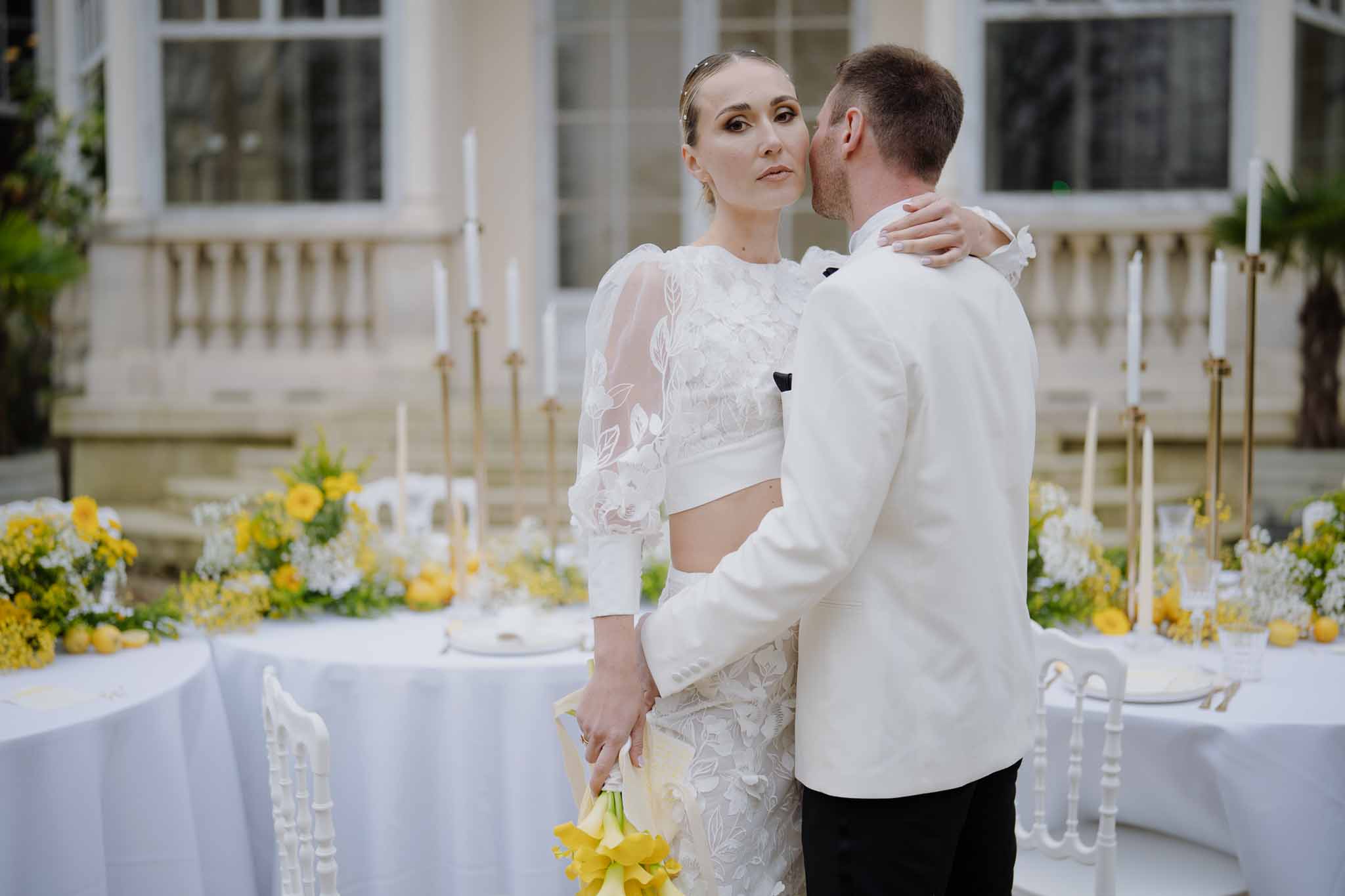 Bride and groom intimate moment during reception in classical courtyard with white linens and gold candelabras