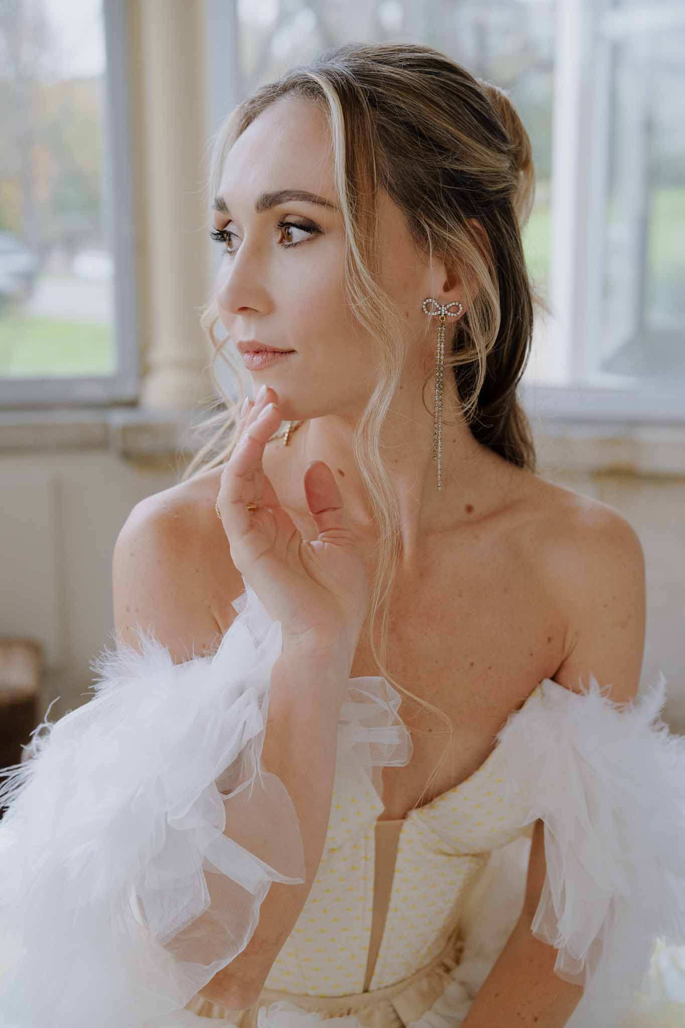 Bride in champagne corset wedding dress during preparation portrait with natural window light