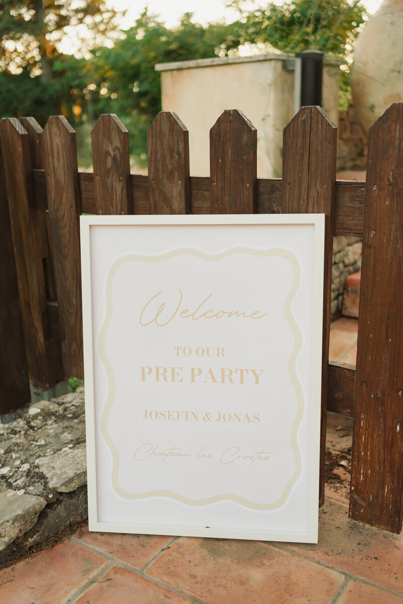 White framed pre-party welcome sign with gold script for Chateau les Crostes on terracotta tiles