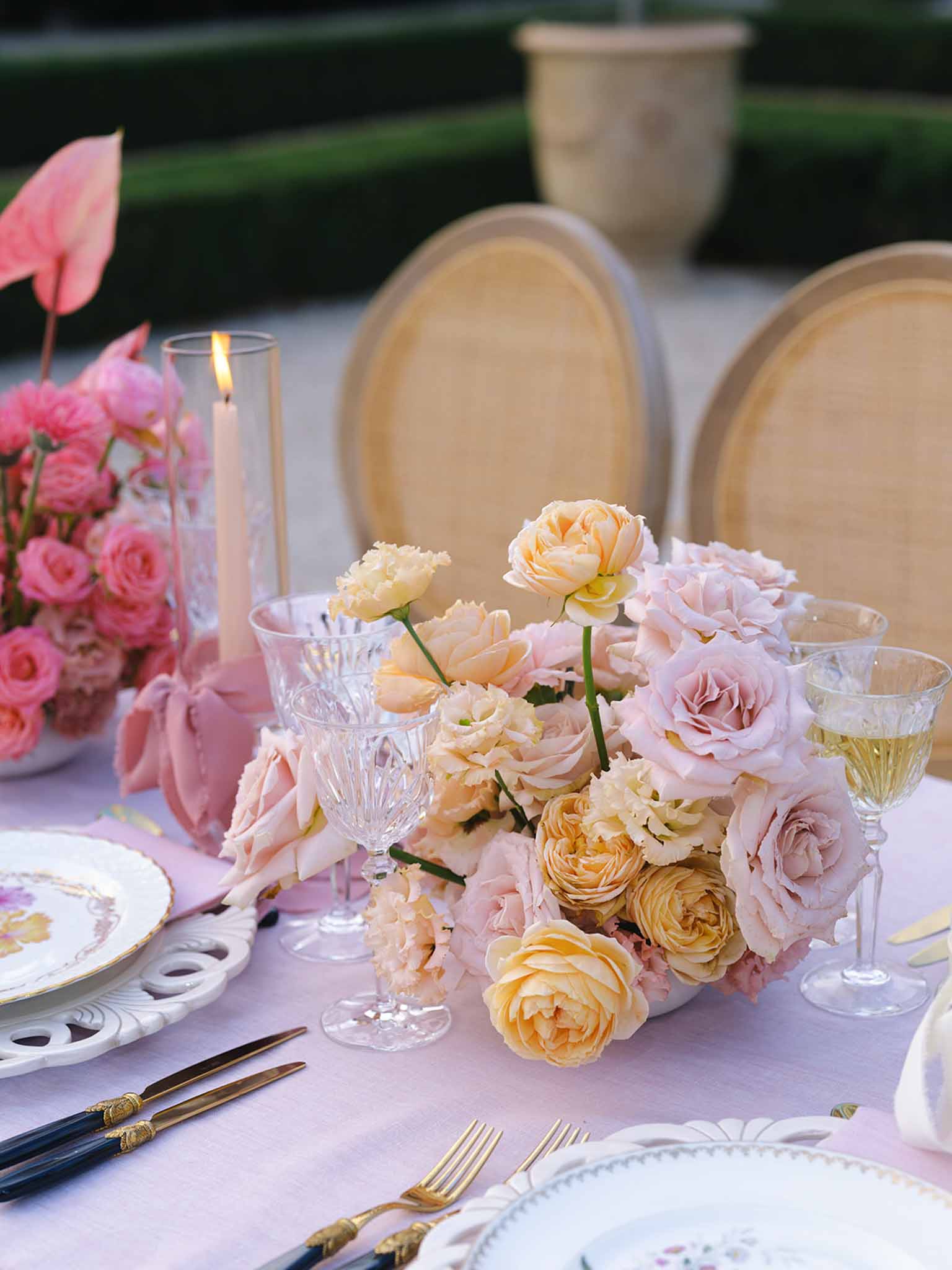 Reception table setting with floral centerpiece at outdoor garden venue